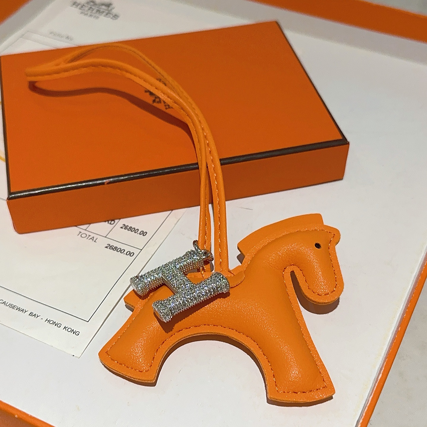 Ciondolo per borsa Hermes Rodeo Horse con pendente Pave H. Pelle arancione, metallo argentato con cristalli trasparenti, lunghezza del cinturino di 12 cm.