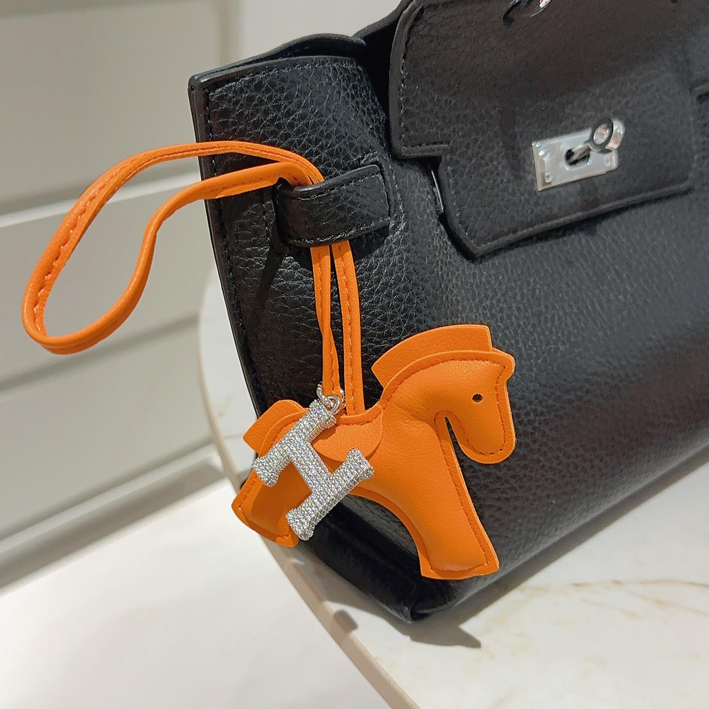 Ciondolo per borsa Hermes Rodeo Horse con pendente Pave H. Pelle arancione, metallo argentato con cristalli trasparenti, lunghezza del cinturino di 12 cm.