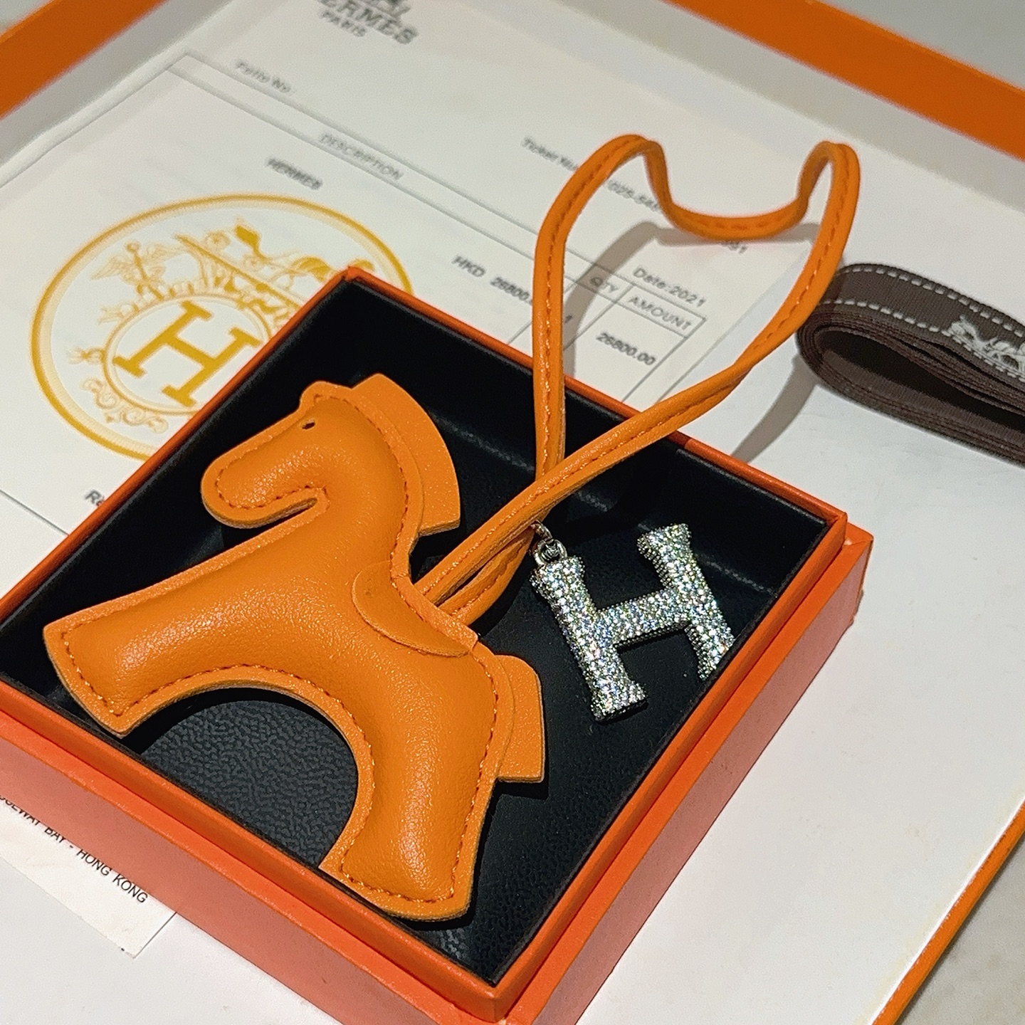 Ciondolo per borsa Hermes Rodeo Horse con pendente Pave H. Pelle arancione, metallo argentato con cristalli trasparenti, lunghezza del cinturino di 12 cm.