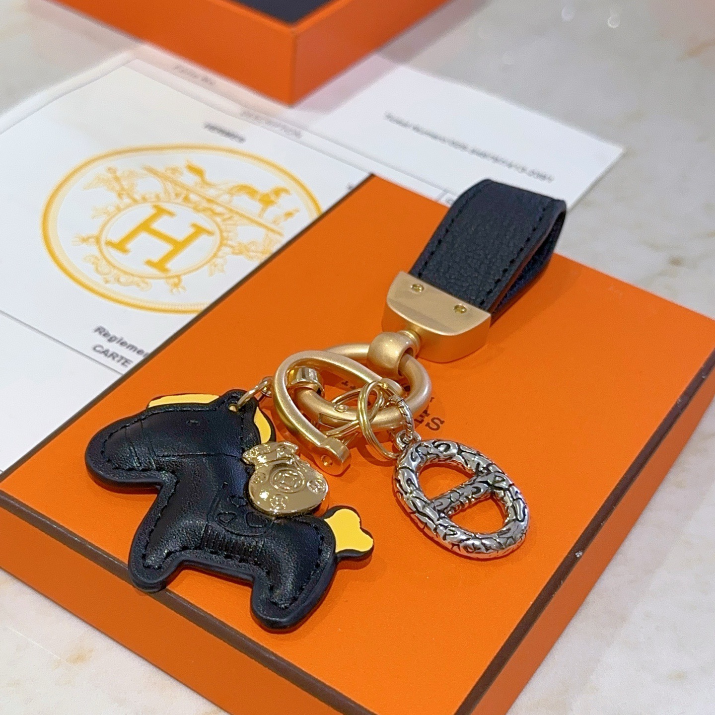 Ciondolo portachiavi Hermes Rodeo Horse Charm Pelle nera con accenti gialli Hardware in metallo color oro e argento Lunghezza totale 10 cm
