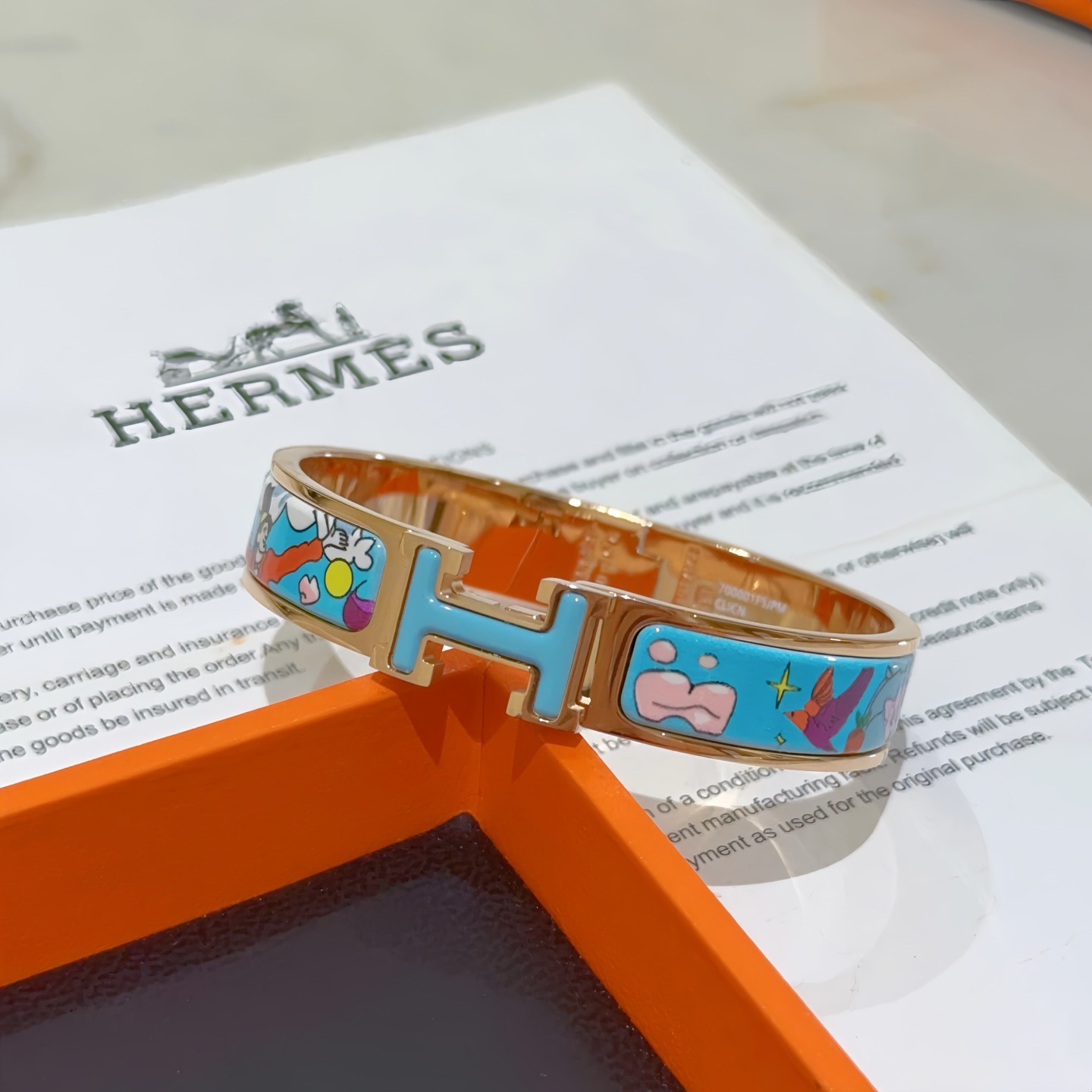 Bracciale Hermes Clic Clac H Metallo placcato oro rosa con smalto azzurro con stampa cartoon multicolor PM