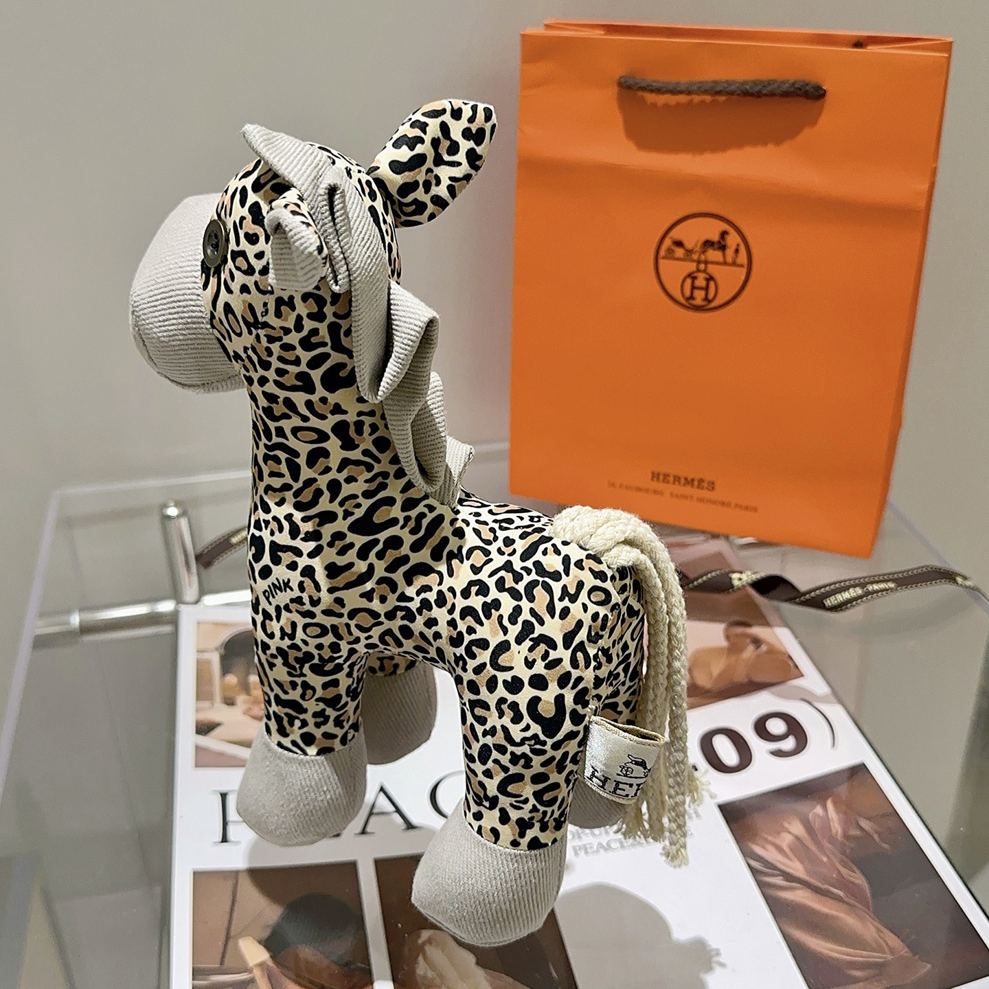 Hermes Hermy Leopard Print Plush Horse Charm pendente Tessuto beige con stampa leopardata nera e marrone chiaro accenti di velluto a coste grigio chiaro coda di cordone intrecciato color crema 25 cm
