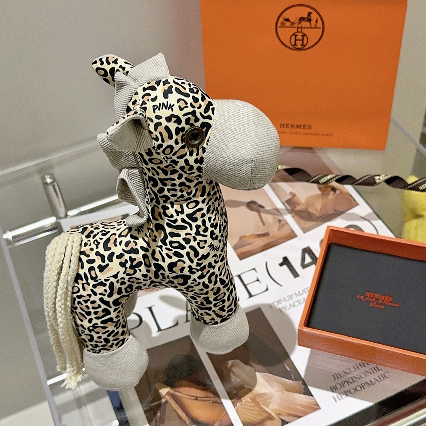 Hermes Hermy Leopard Print Plush Horse Charm pendente Tessuto beige con stampa leopardata nera e marrone chiaro accenti di velluto a coste grigio chiaro coda di cordone intrecciato color crema 25 cm