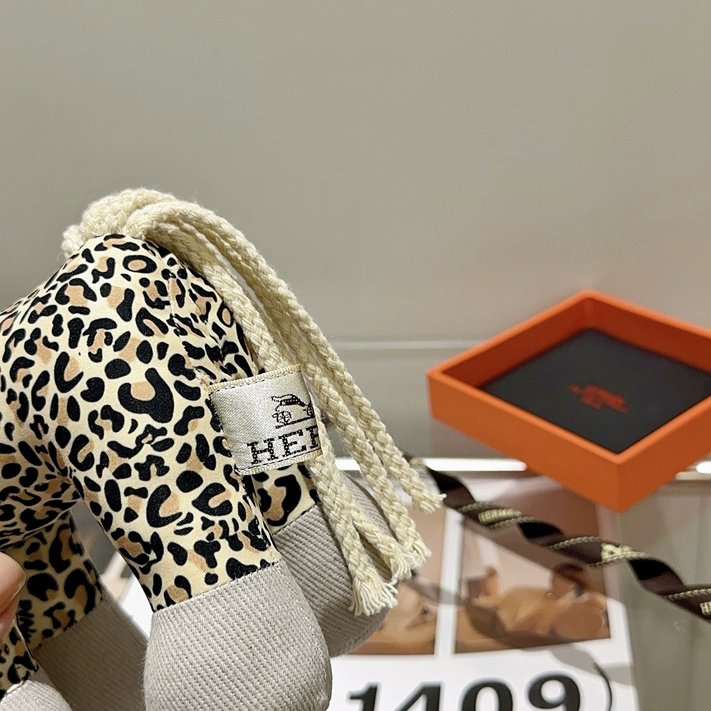 Hermes Hermy Leopard Print Plush Horse Charm pendente Tessuto beige con stampa leopardata nera e marrone chiaro accenti di velluto a coste grigio chiaro coda di cordone intrecciato color crema 25 cm