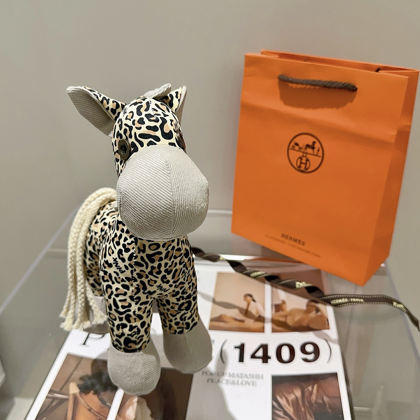 Hermes Hermy Leopard Print Plush Horse Charm pendente Tessuto beige con stampa leopardata nera e marrone chiaro accenti di velluto a coste grigio chiaro coda di cordone intrecciato color crema 25 cm