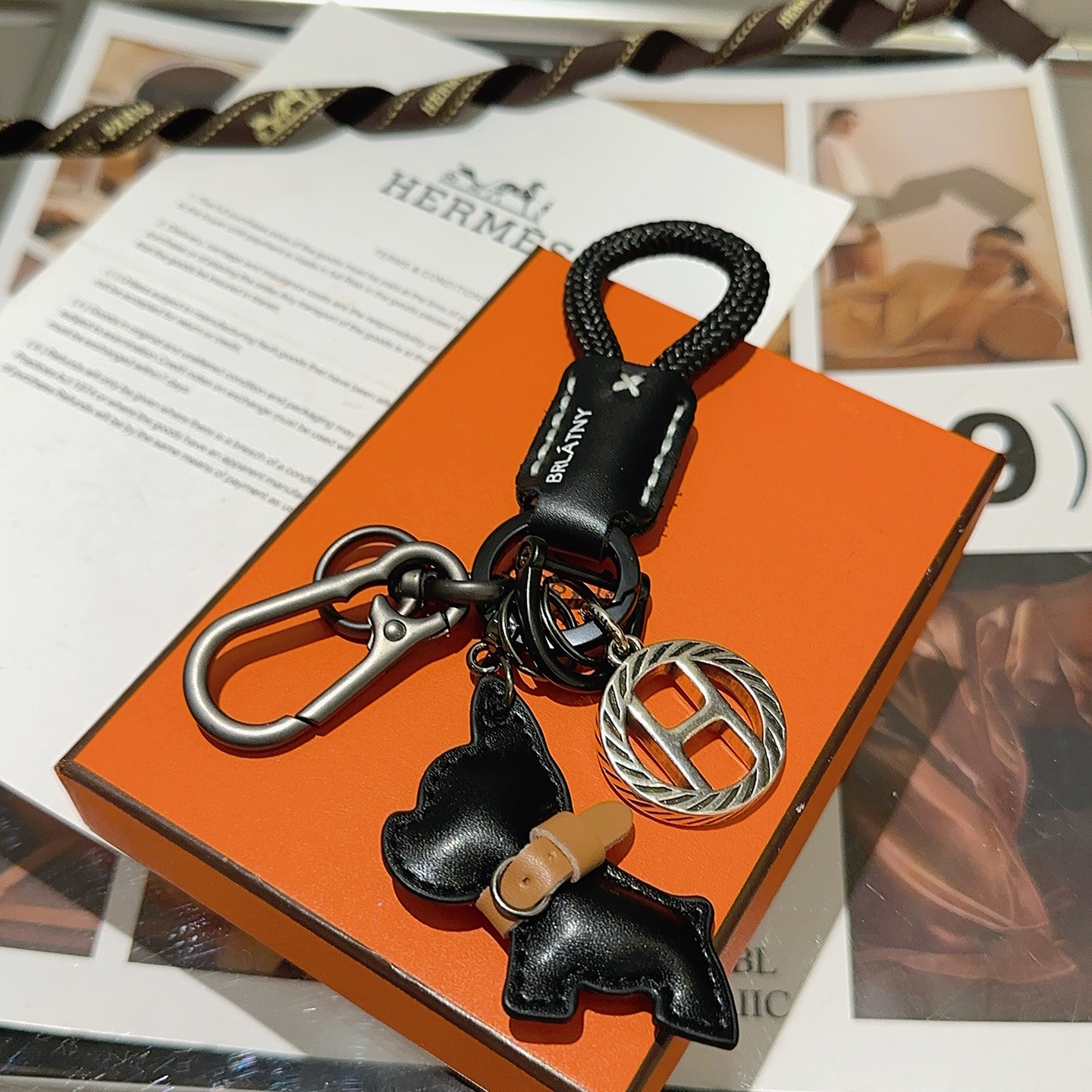 Hermes H Logo Bulldog Charm Portachiavi pendente canna di fucile metallo argento cordone intrecciato nero pelle nera accento in pelle marrone chiaro lunghezza totale 10 cm