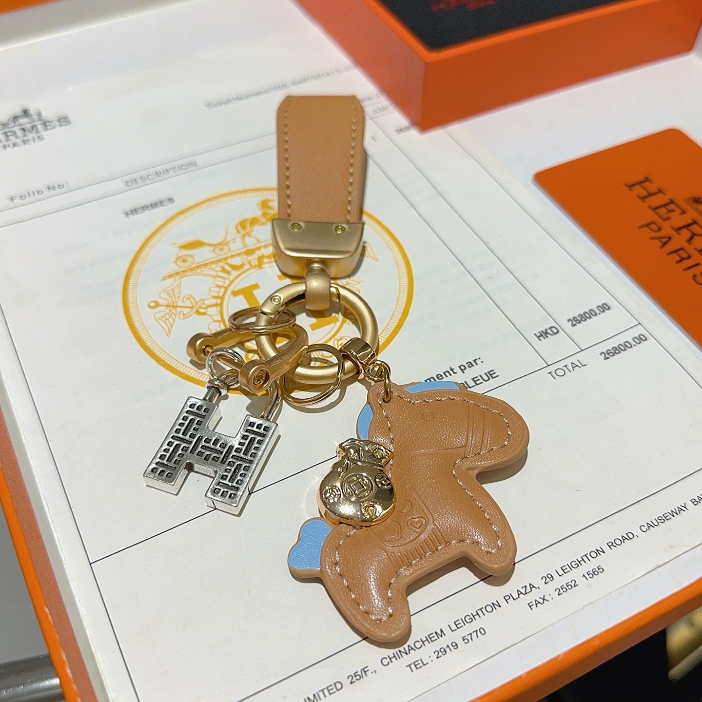 Ciondolo portachiavi Hermes Horse Charm Pelle marrone chiaro con accenti azzurri hardware oro opaco ciondolo con lucchetto H color argento lunghezza totale 10 cm