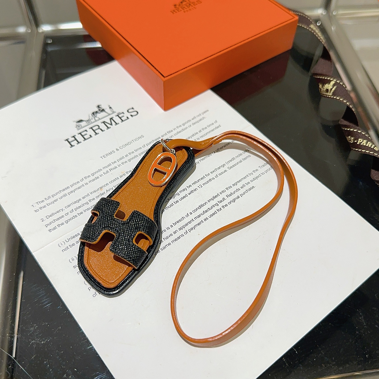 Hermes Oran Sandalo Borsa Ciondolo ciondolo in pelle marrone chiaro pelle a grana nera smalto arancione metallo argentato lunghezza cinturino 18 cm