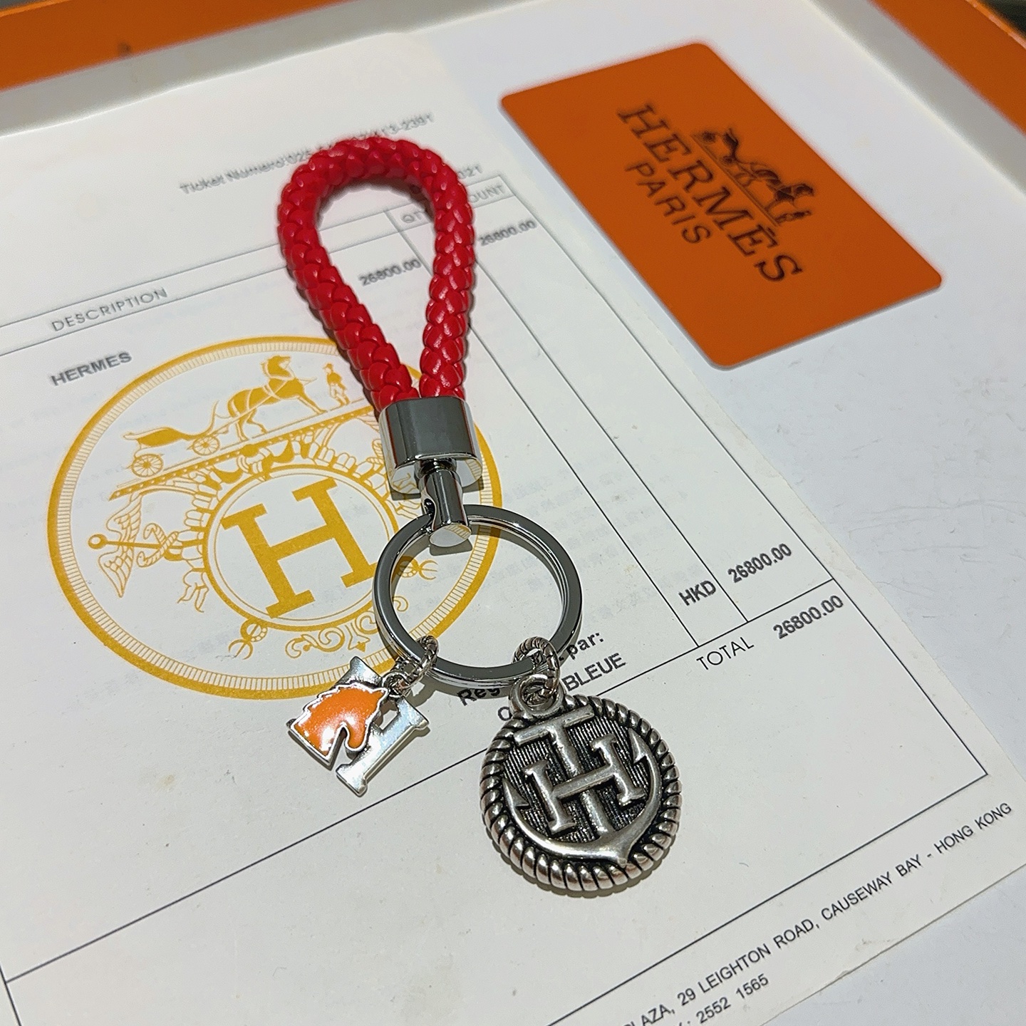Chaveiro trançado com logotipo Hermes H, pingente de couro trançado vermelho, metal prateado, esmalte laranja, 10 cm de comprimento total
