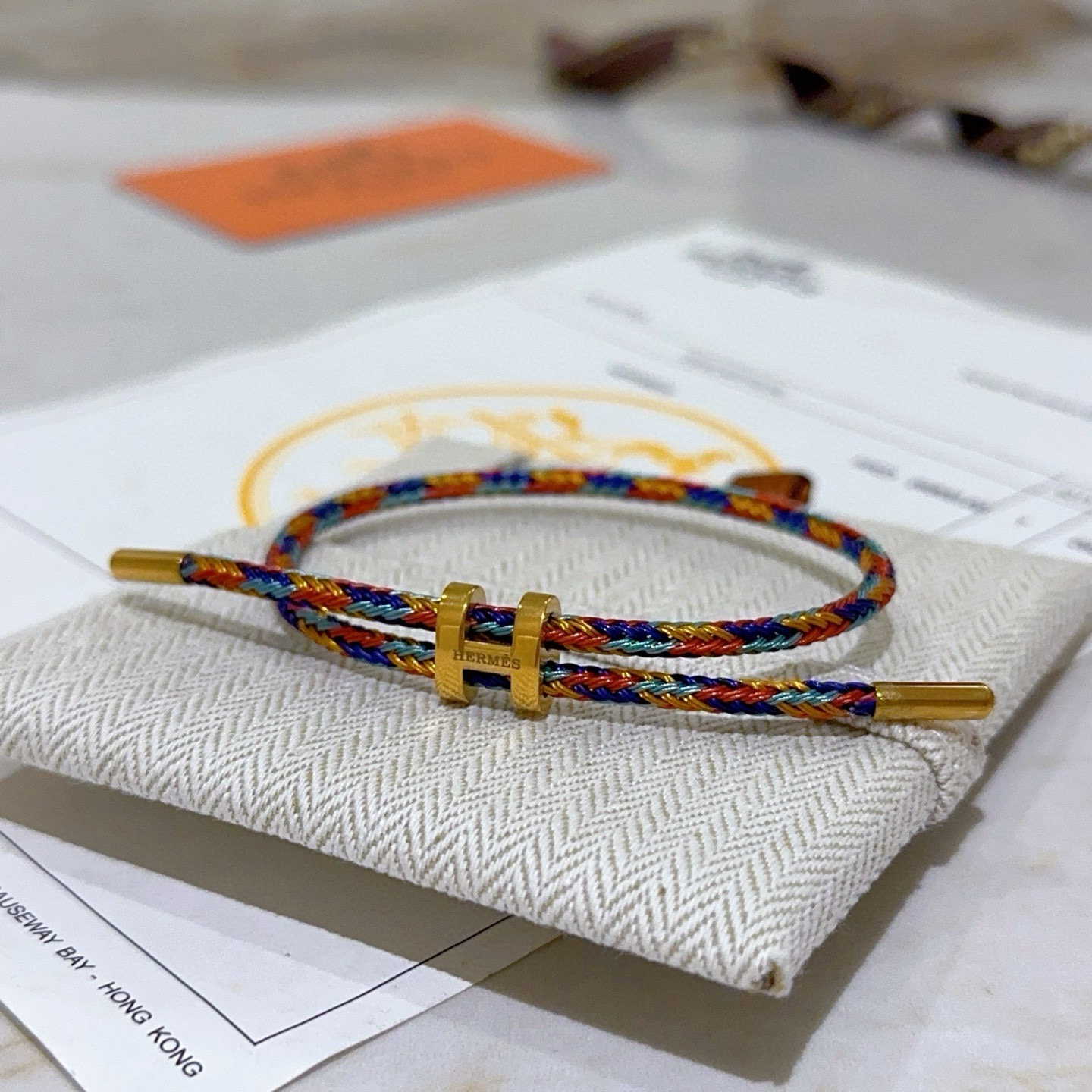 Bracciale Hermes H d Ancre hardware in metallo color oro cordone intrecciato multicolore rosso blu oro verde acqua nodo scorrevole regolabile adatto a polsi di 15-18 cm