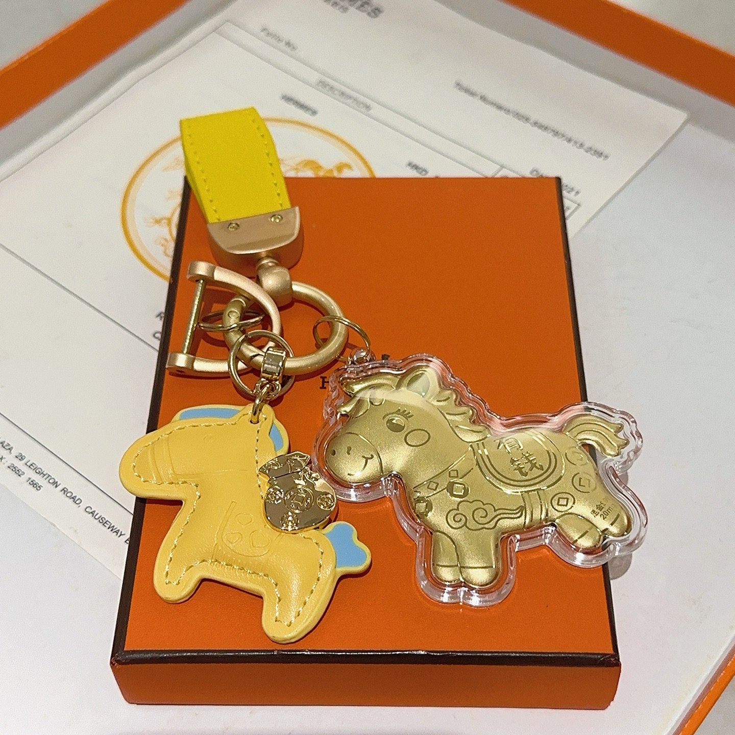 Hermes Rodeo Horse Lucky Money Key Charm Ciondolo Hardware in oro opaco Pelle gialla con accenti azzurri Ciondolo a cavallo in lamina d'oro in involucro acrilico trasparente Lunghezza totale 10 cm