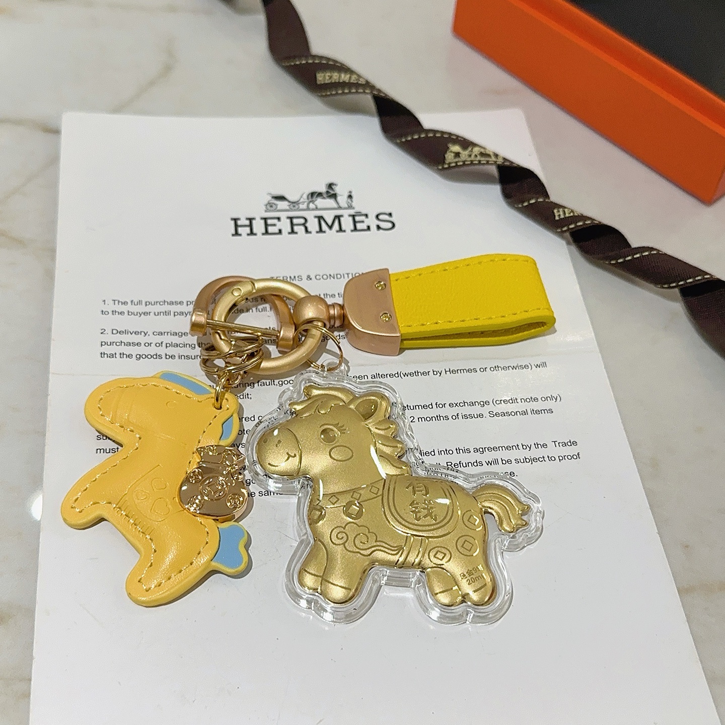 Hermes Rodeo Horse Lucky Money Key Charm Ciondolo Hardware in oro opaco Pelle gialla con accenti azzurri Ciondolo a cavallo in lamina d'oro in involucro acrilico trasparente Lunghezza totale 10 cm