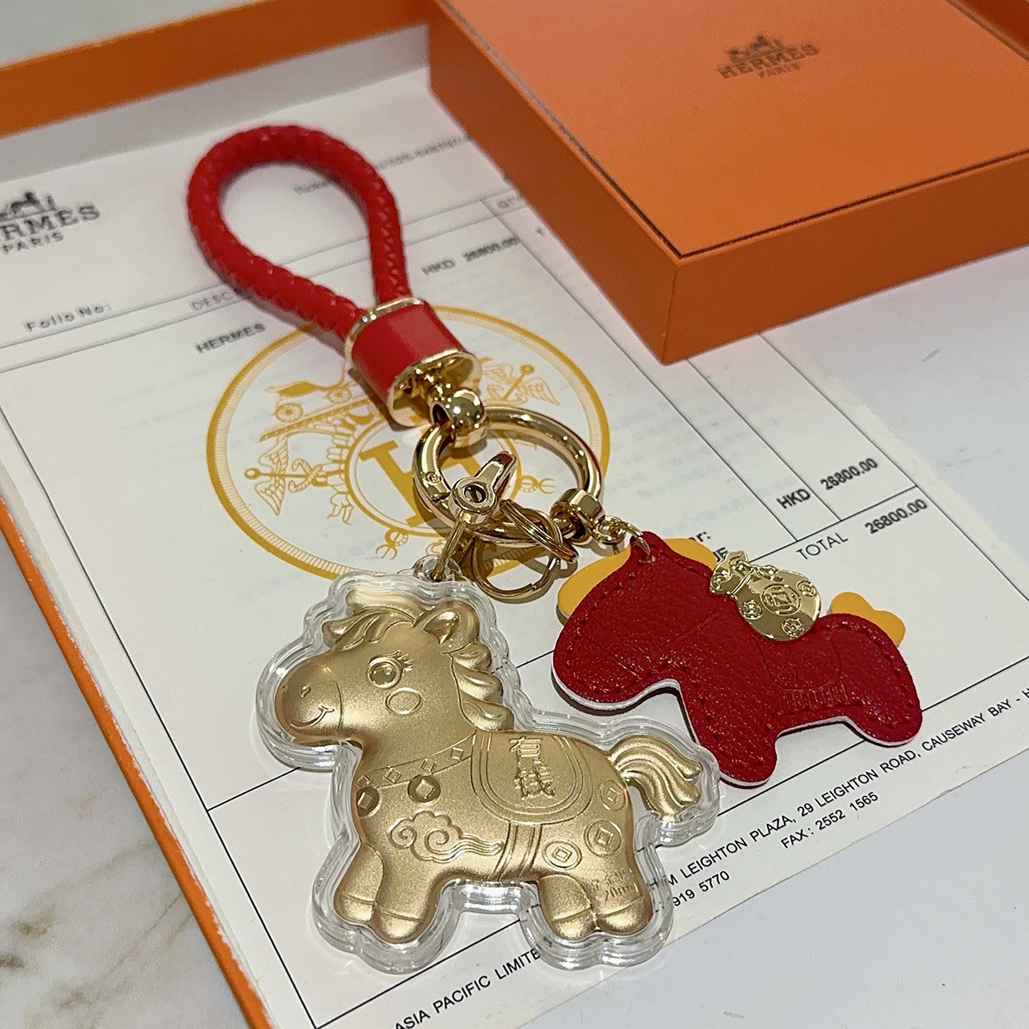 Hermes Lucky Horse Charm Portachiavi Ciondolo Portachiavi in ​​pelle intrecciata rossa in metallo color oro Ciondolo cavallo in pelle rossa Ciondolo cavallo dorato con involucro protettivo trasparente Dettagli accenti gialli Lunghezza totale 10 cm