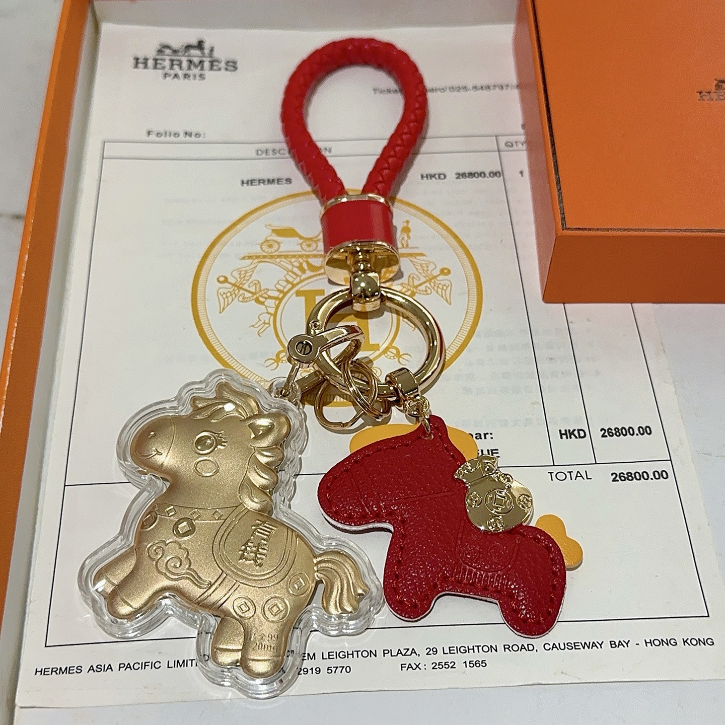 Hermes Lucky Horse Charm Portachiavi Ciondolo Portachiavi in ​​pelle intrecciata rossa in metallo color oro Ciondolo cavallo in pelle rossa Ciondolo cavallo dorato con involucro protettivo trasparente Dettagli accenti gialli Lunghezza totale 10 cm