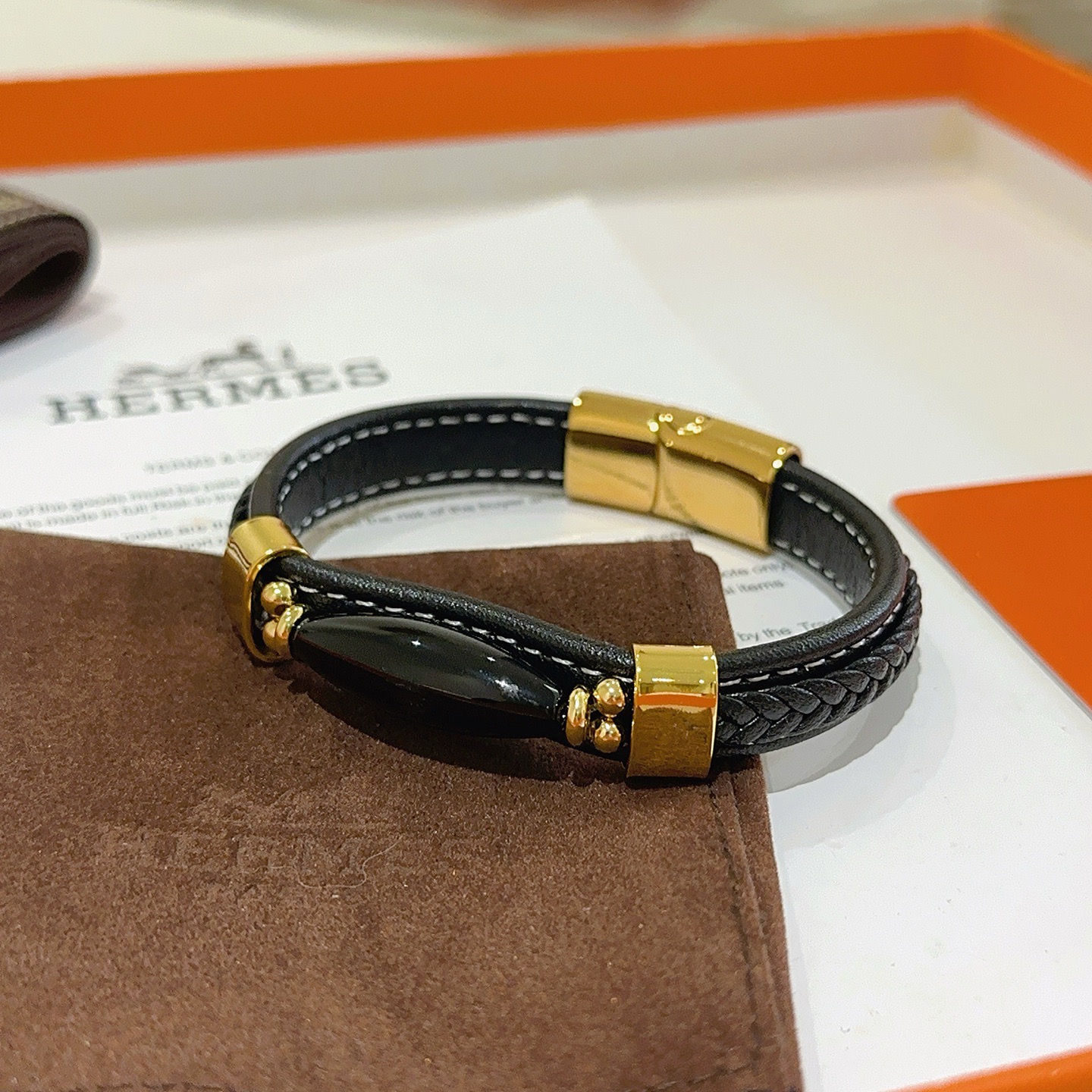 Pulsera Hermes New Anger Forest de cuero trenzado negro con herrajes de metal en tono dorado y detalle de ónix negro, 18 cm