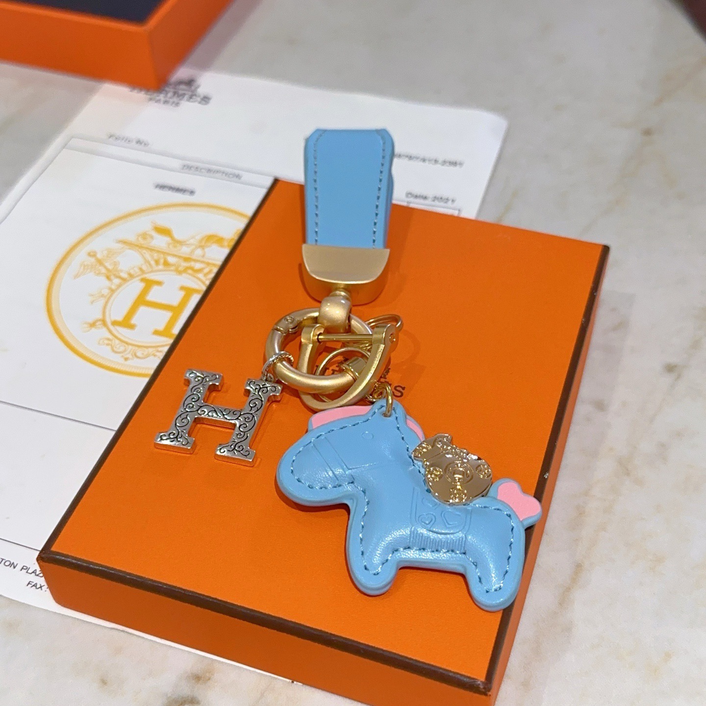 Hermes Rodeo Horse H Logo Key Charm colgante Cuero azul claro herrajes dorados mate Charm H en tono plateado Detalles decorativos en rosa 8 cm de longitud total