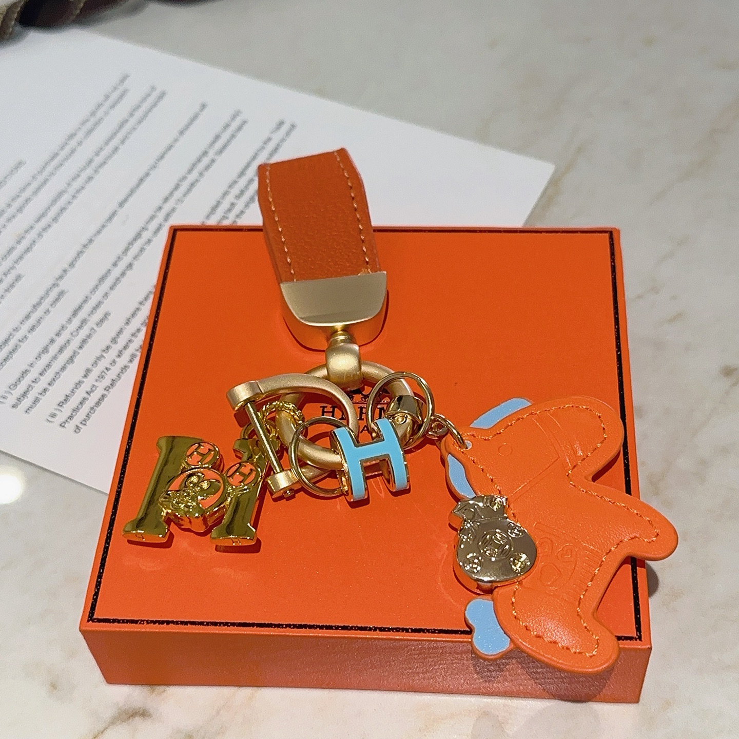 Ciondolo portachiavi Hermes Rodeo Horse Charm Pelle arancione con accenti azzurri Hardware in metallo color oro, lunghezza totale 10 cm