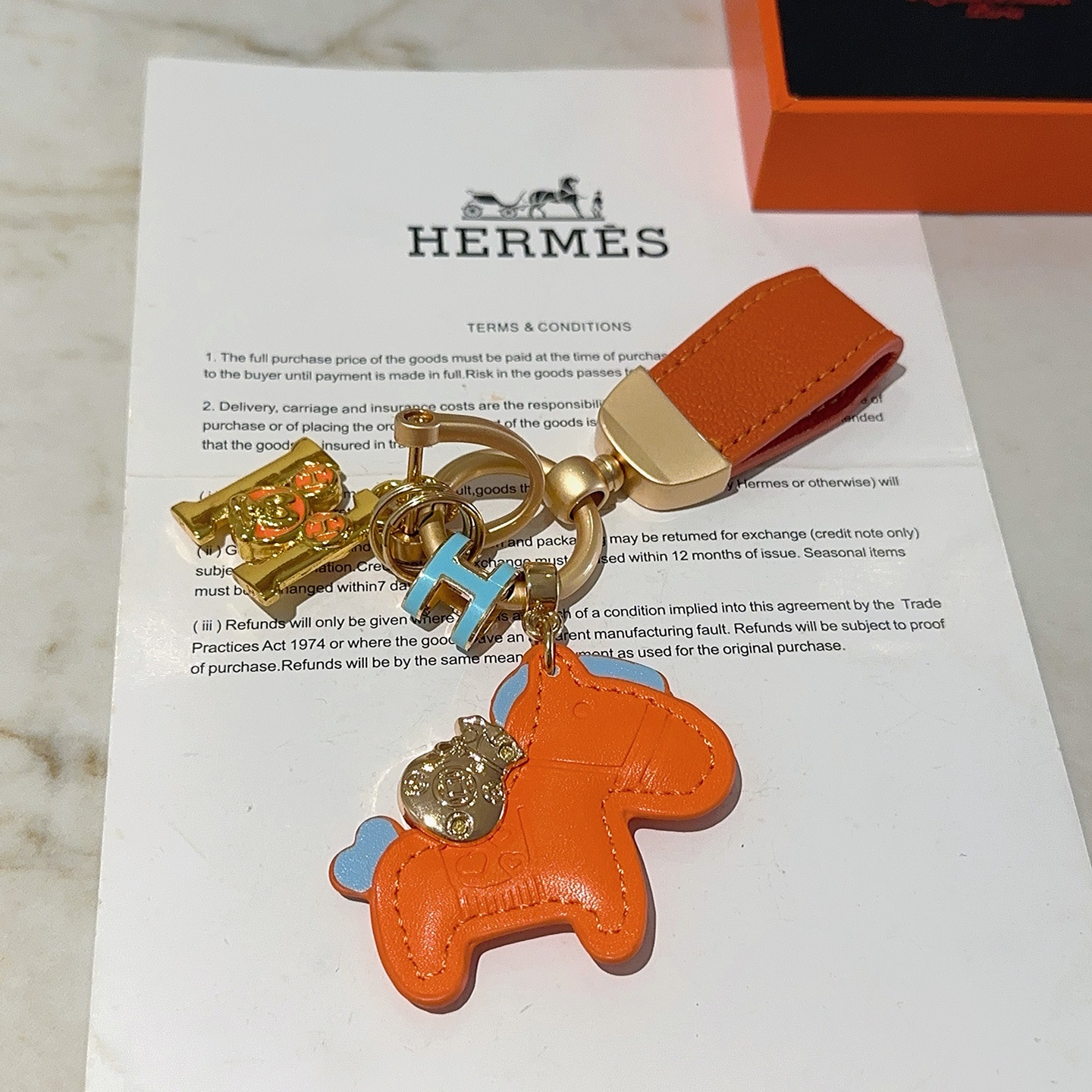Ciondolo portachiavi Hermes Rodeo Horse Charm Pelle arancione con accenti azzurri Hardware in metallo color oro, lunghezza totale 10 cm