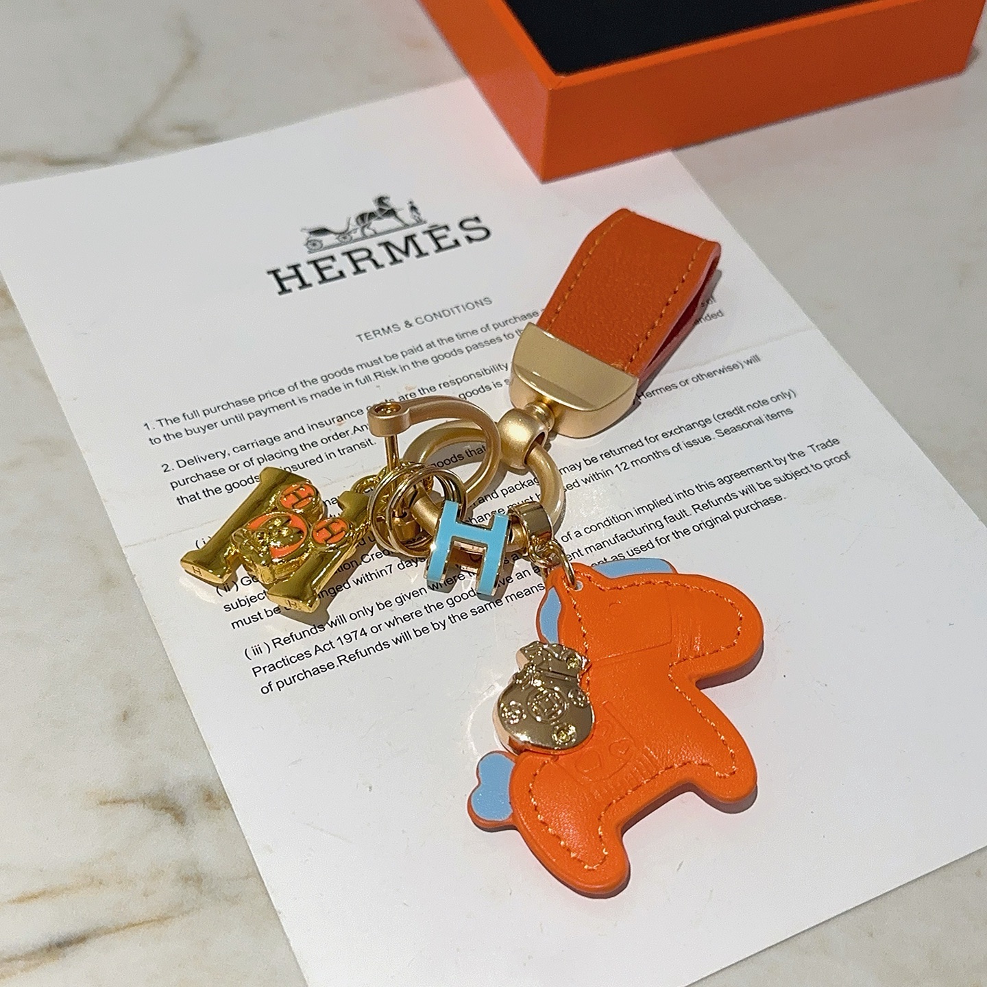 Ciondolo portachiavi Hermes Rodeo Horse Charm Pelle arancione con accenti azzurri Hardware in metallo color oro, lunghezza totale 10 cm