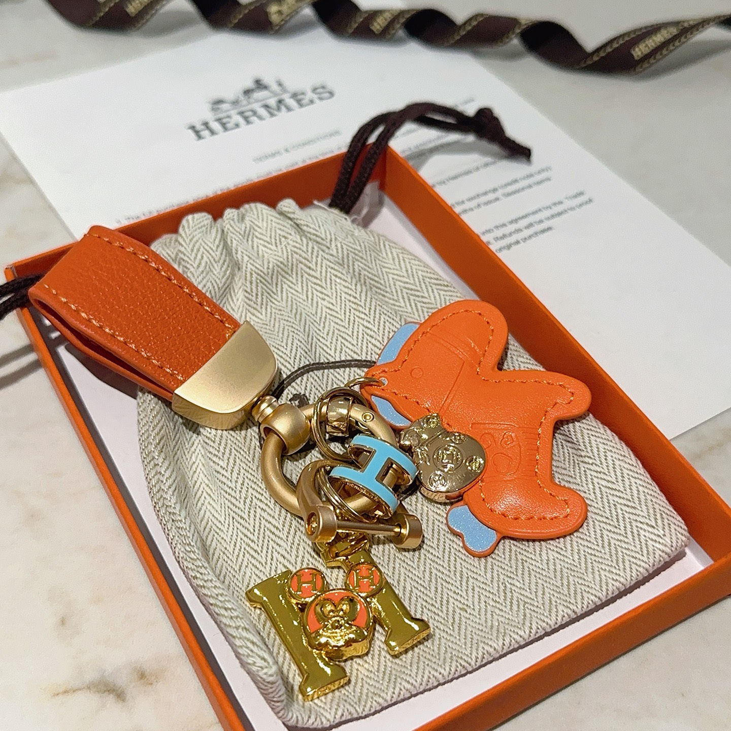 Ciondolo portachiavi Hermes Rodeo Horse Charm Pelle arancione con accenti azzurri Hardware in metallo color oro, lunghezza totale 10 cm