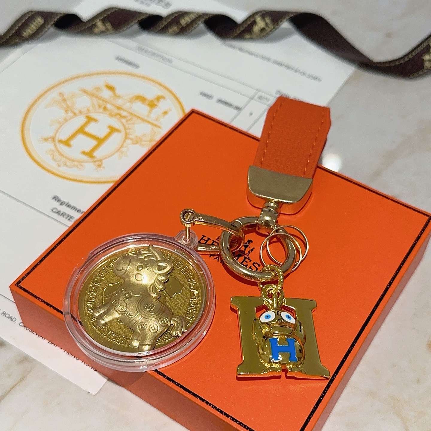 Ciondolo portachiavi Hermes H Logo Medaglione cavallo Medaglione in oro smaltato blu in metallo color oro, lunghezza totale 10 cm