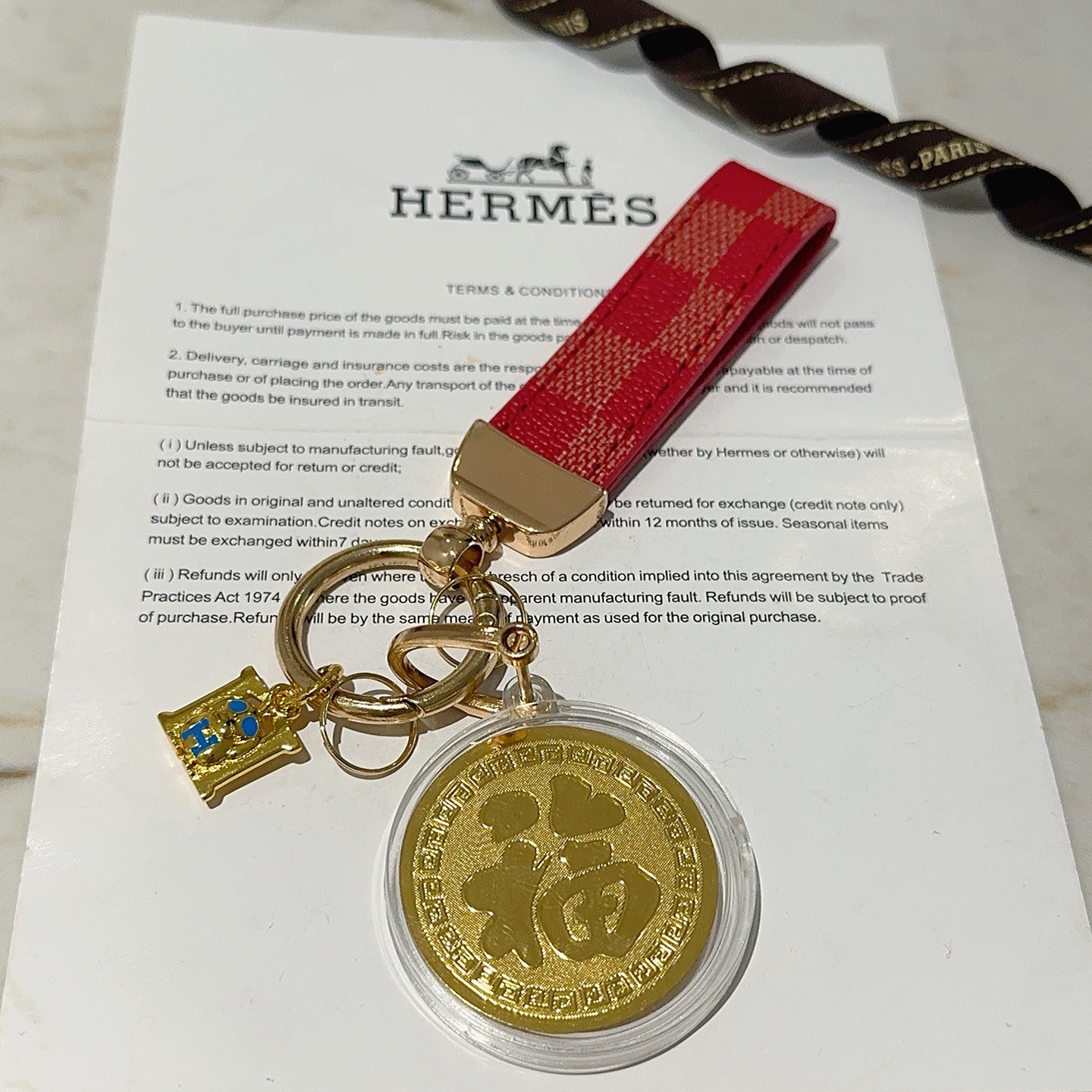 Ciondolo portachiavi Hermes Lucky Horse Fu Charm Cinturino in tela rivestita a scacchi rossi Hardware in metallo color oro Medaglione dorato Ciondolo H in smalto blu Custodia protettiva trasparente con medaglione 10 cm di lunghezza totale
