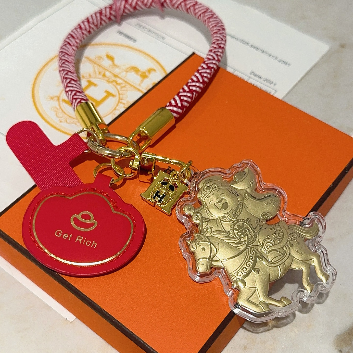 Hermes Get Rich God of Wealth on Horse Key Ciondolo con ciondolo Cordone intrecciato rosso e bianco metallo color oro pelle rossa rivestimento in acrilico trasparente dettagli in lamina d'oro Lunghezza del passante da polso di 18 cm