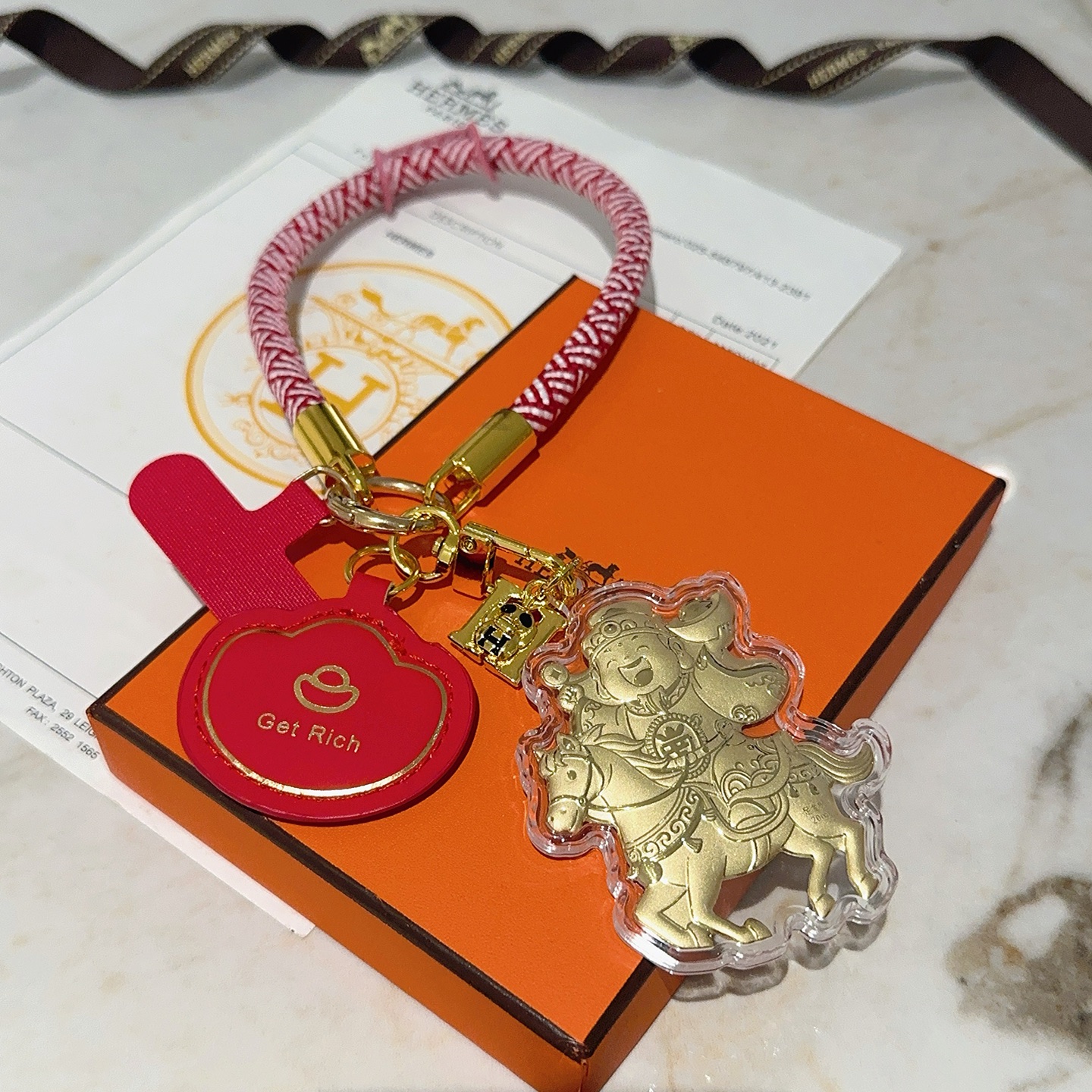 Hermes Get Rich God of Wealth on Horse Key Ciondolo con ciondolo Cordone intrecciato rosso e bianco metallo color oro pelle rossa rivestimento in acrilico trasparente dettagli in lamina d'oro Lunghezza del passante da polso di 18 cm