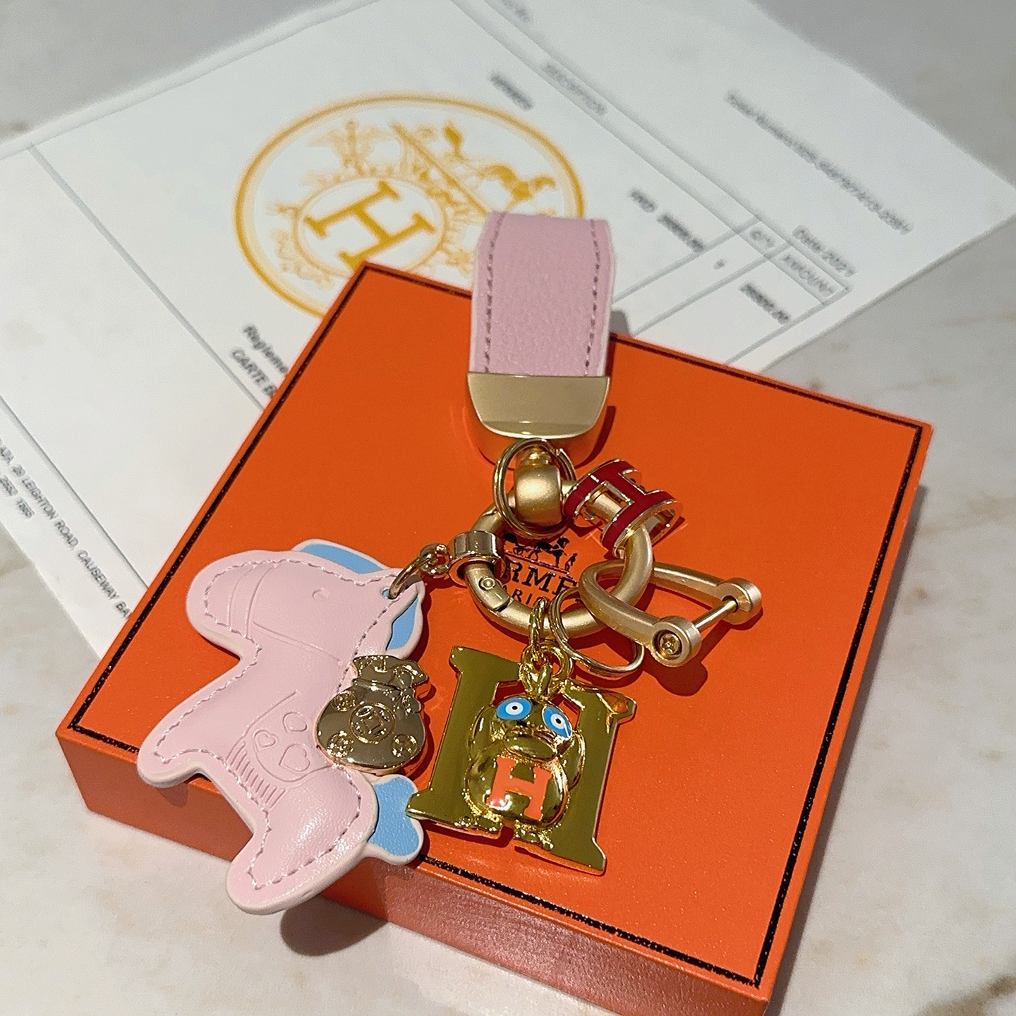 Hermes H Logo Cartoon Horse Charm Chaveiro pingente de metal dourado com couro rosa azul claro vermelho laranja esmalte detalhes 10 cm de comprimento total