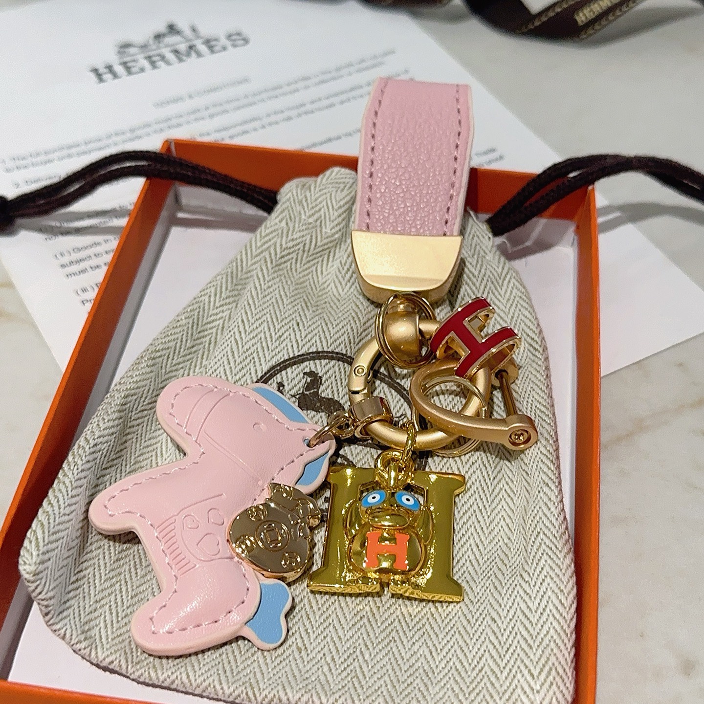 Hermes H Logo Cartoon Horse Charm Chaveiro pingente de metal dourado com couro rosa azul claro vermelho laranja esmalte detalhes 10 cm de comprimento total