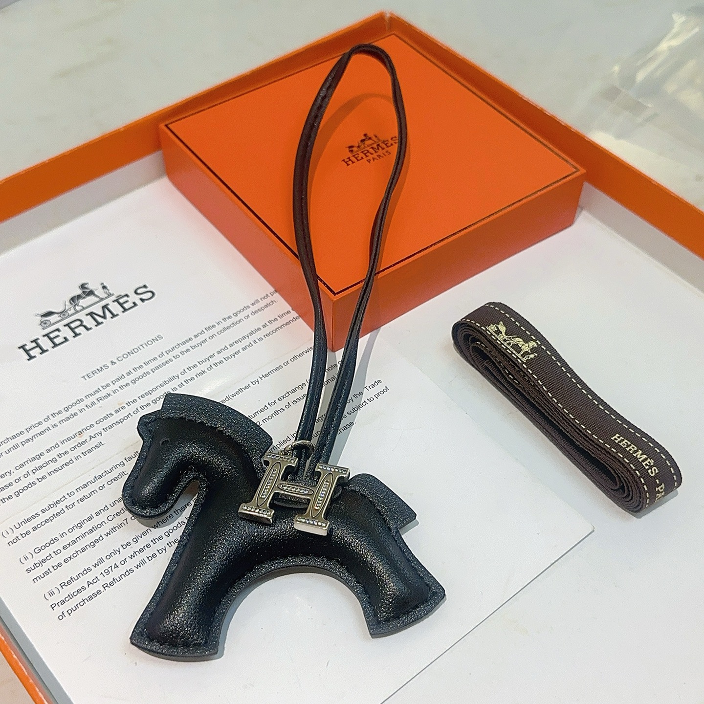 Ciondolo Hermes Rodeo H Charm in pelle nera, metallo color argento con accenti in cristallo trasparente, 80 cm