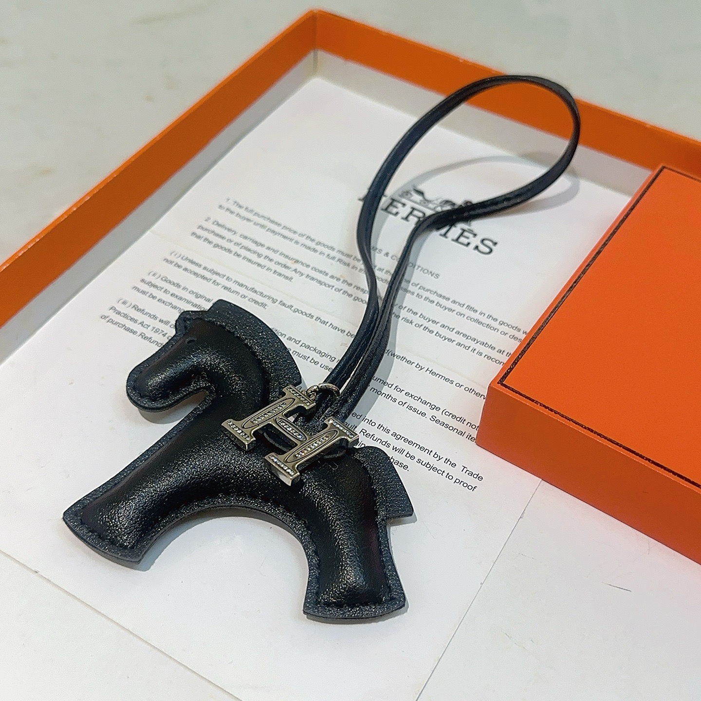 Ciondolo Hermes Rodeo H Charm in pelle nera, metallo color argento con accenti in cristallo trasparente, 80 cm