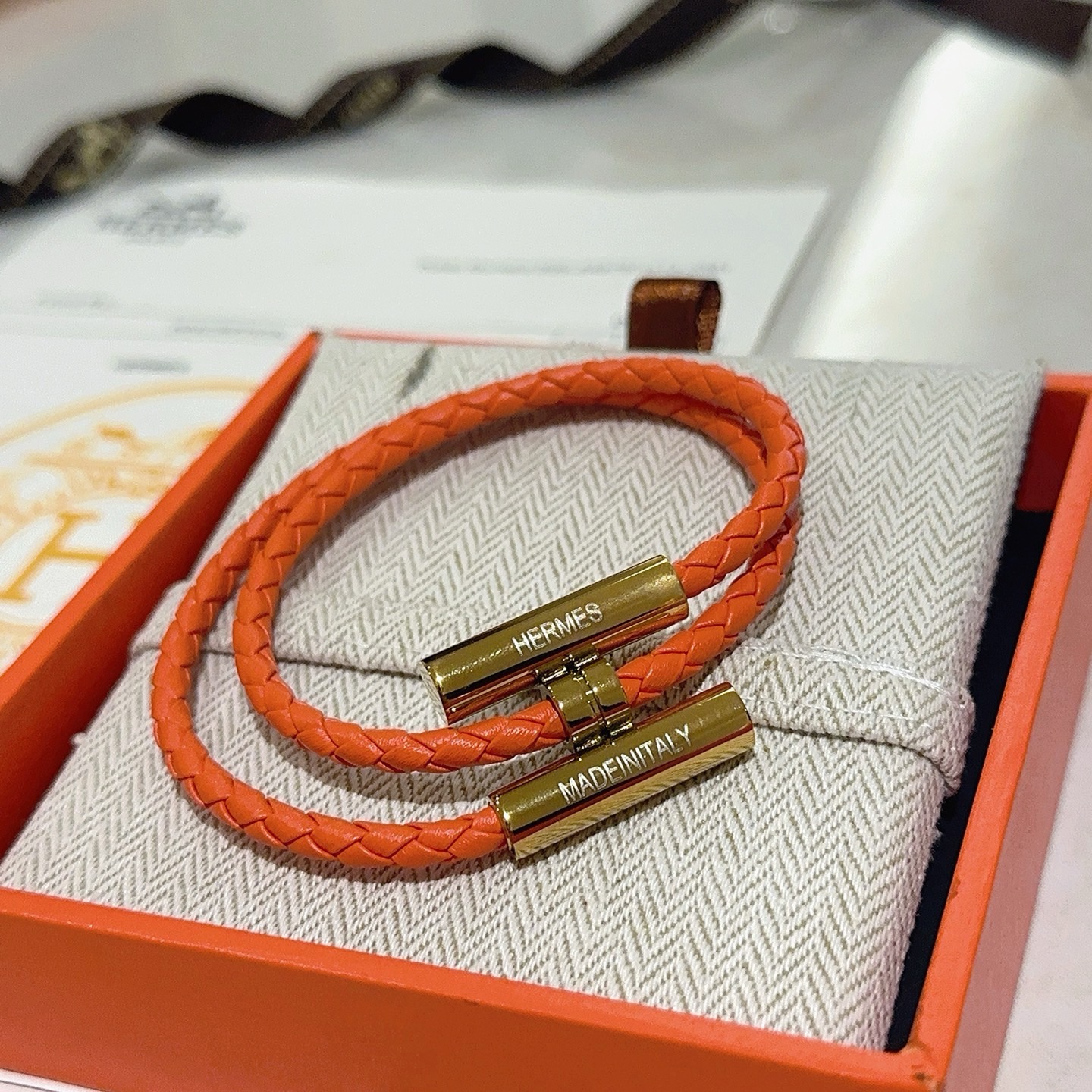 Pulseira Hermes Tournis Tresse Couro trançado laranja com detalhes em metal dourado 19 cm