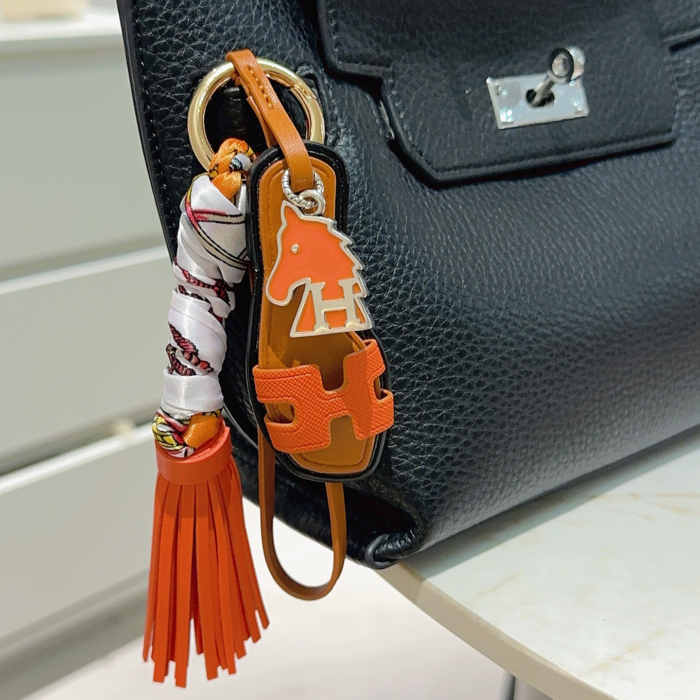 Hermes Oran Sandalo Borsa con nappa Ciondolo con ciondolo Pelle arancione pelle marrone chiaro finiture nere metallo argentato seta stampata multicolore hardware color oro 12 cm di lunghezza totale