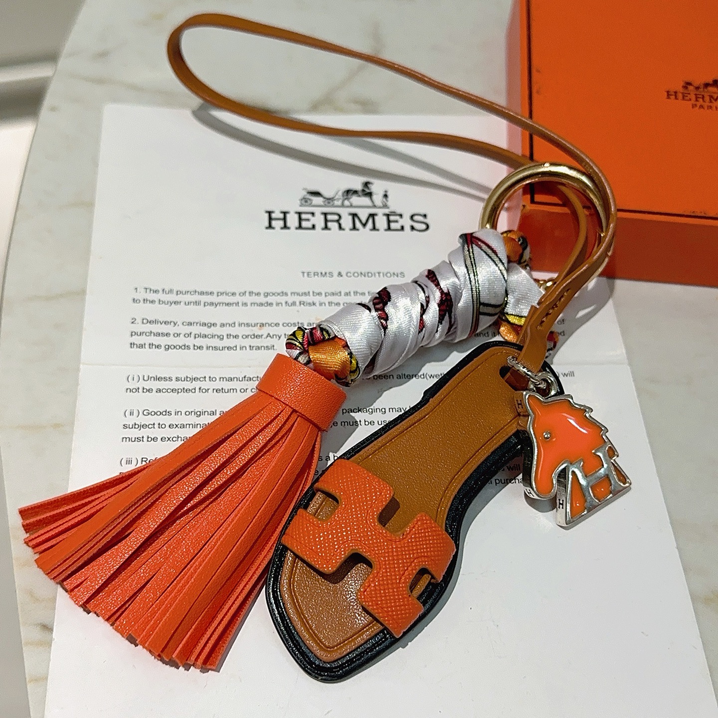 Hermes Oran Sandalo Borsa con nappa Ciondolo con ciondolo Pelle arancione pelle marrone chiaro finiture nere metallo argentato seta stampata multicolore hardware color oro 12 cm di lunghezza totale