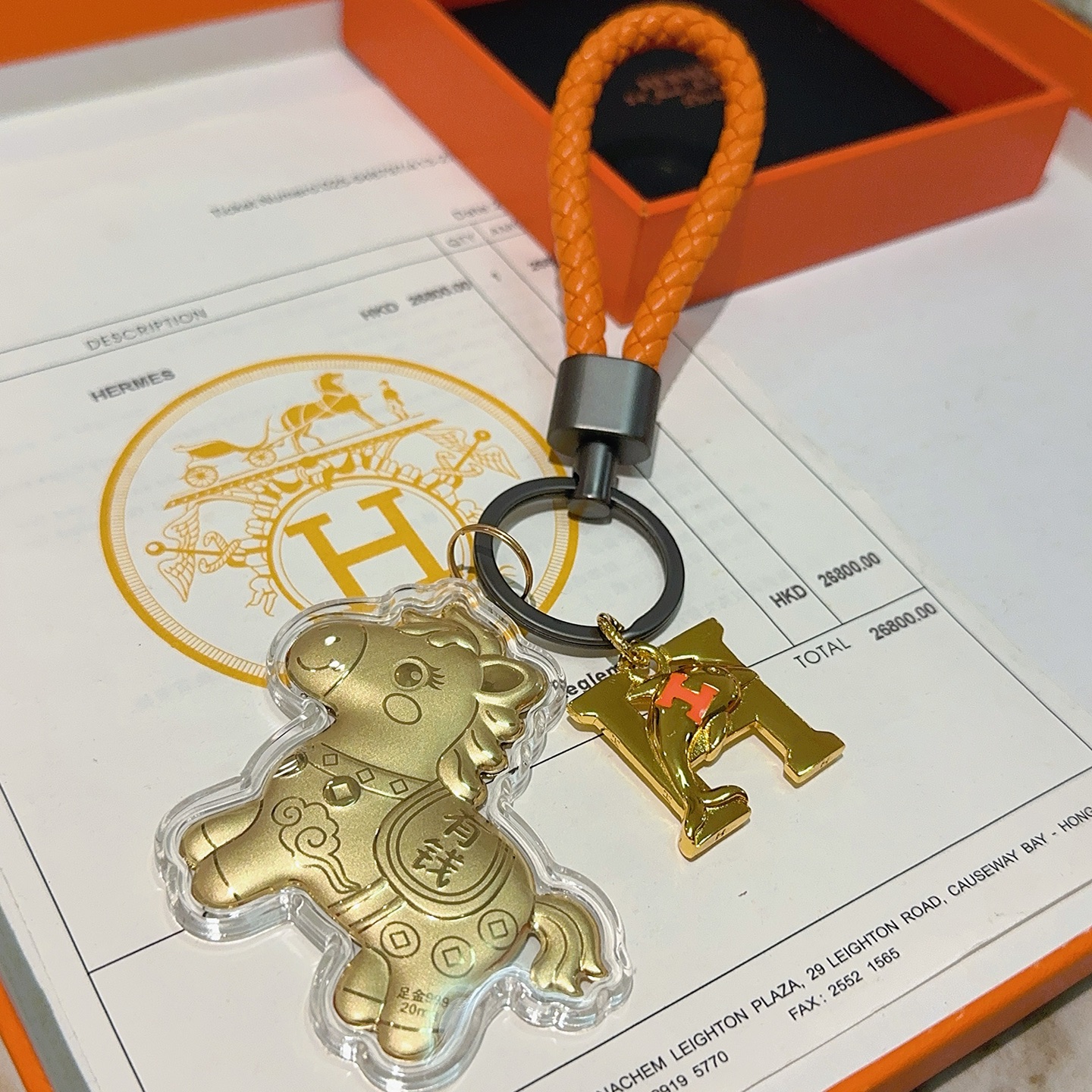 Hermes Lucky Horse H Logo Portachiavi Ciondolo con ciondolo Pelle intrecciata arancione Hardware in canna di fucile Ciondoli in metallo color oro con accento H arancione Rivestimento in acrilico trasparente 10 cm Cinturino intrecciato 4 cm