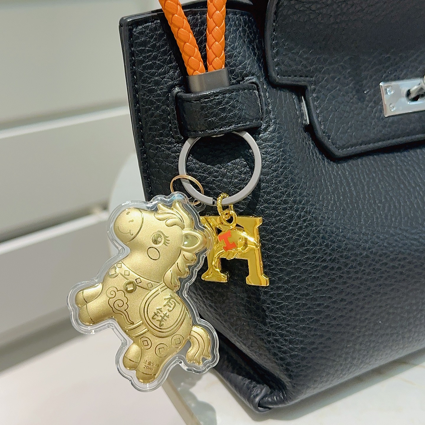 Hermes Lucky Horse H Logo Portachiavi Ciondolo con ciondolo Pelle intrecciata arancione Hardware in canna di fucile Ciondoli in metallo color oro con accento H arancione Rivestimento in acrilico trasparente 10 cm Cinturino intrecciato 4 cm
