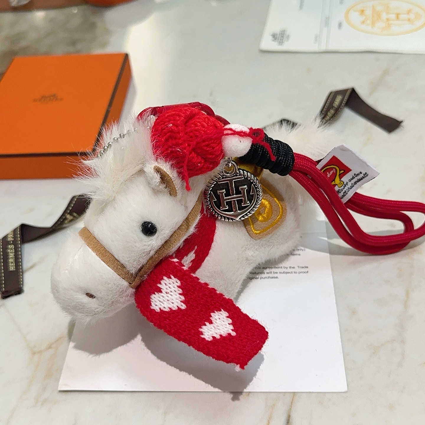 Ciondolo Hermes Giddy Horse Charm bianco peluche tessuto in maglia rossa metallo argentato antico metallo color oro tessuto marrone chiaro lunghezza totale cinturino 12 cm