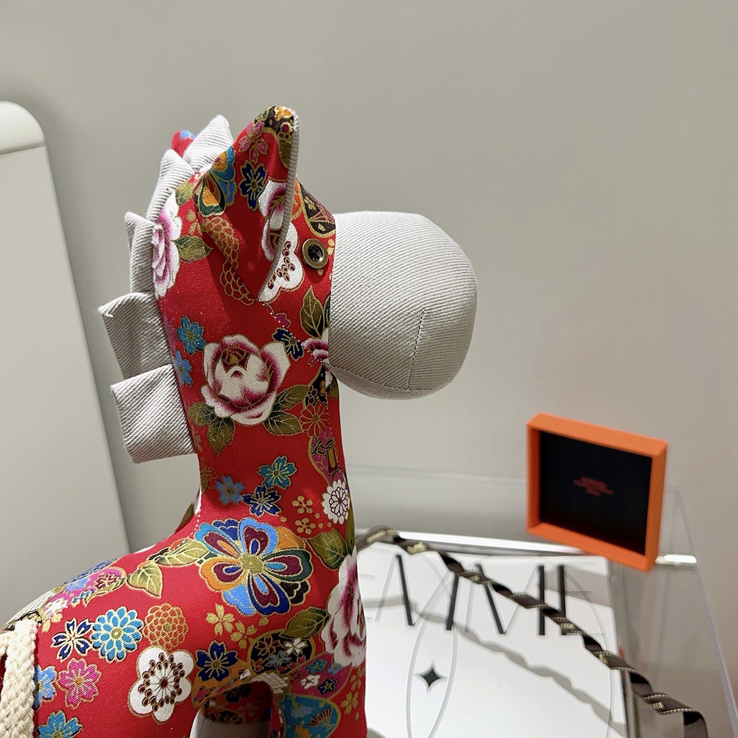 Hermes Spilla in peluche Hermes Horse Tessuto stampato floreale rosso con accenti in tessuto grigio chiaro coda di cavo bianco sporco dettaglio occhiello in metallo 35 cm