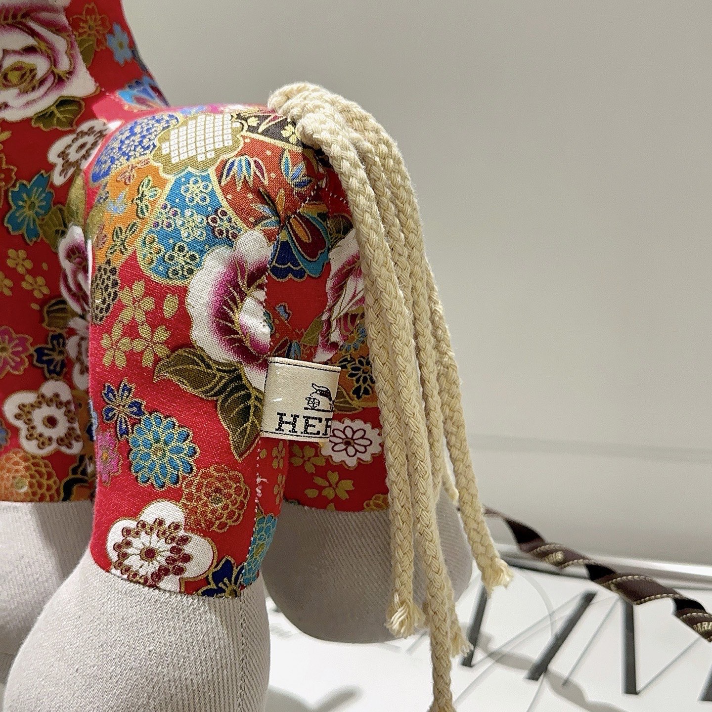 Hermes Spilla in peluche Hermes Horse Tessuto stampato floreale rosso con accenti in tessuto grigio chiaro coda di cavo bianco sporco dettaglio occhiello in metallo 35 cm