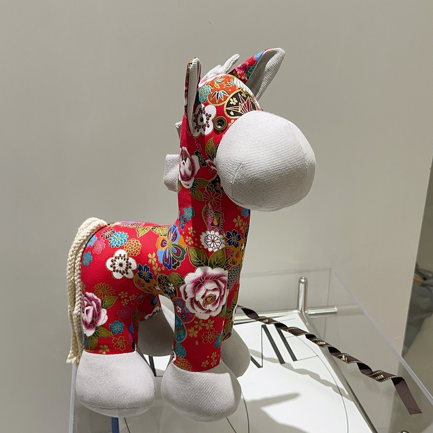 Hermes Spilla in peluche Hermes Horse Tessuto stampato floreale rosso con accenti in tessuto grigio chiaro coda di cavo bianco sporco dettaglio occhiello in metallo 35 cm