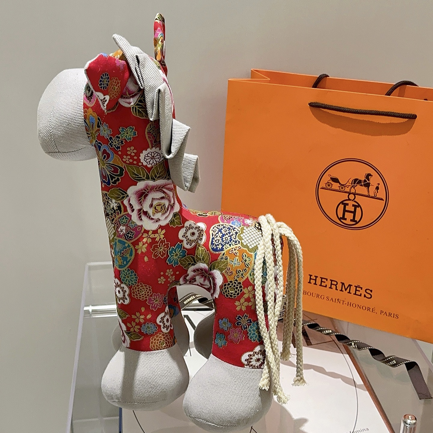 Hermes Spilla in peluche Hermes Horse Tessuto stampato floreale rosso con accenti in tessuto grigio chiaro coda di cavo bianco sporco dettaglio occhiello in metallo 35 cm