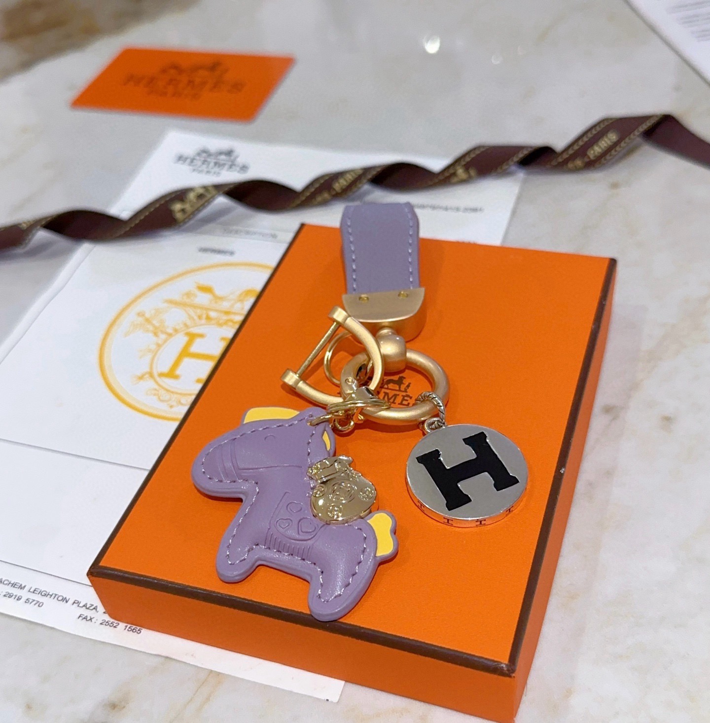 Ciondolo chiave Hermes Rodeo Horse H Logo ciondolo in metallo color oro opaco pelle lavanda accento in pelle gialla metallo argentato con logo H smaltato nero lunghezza totale 10 cm