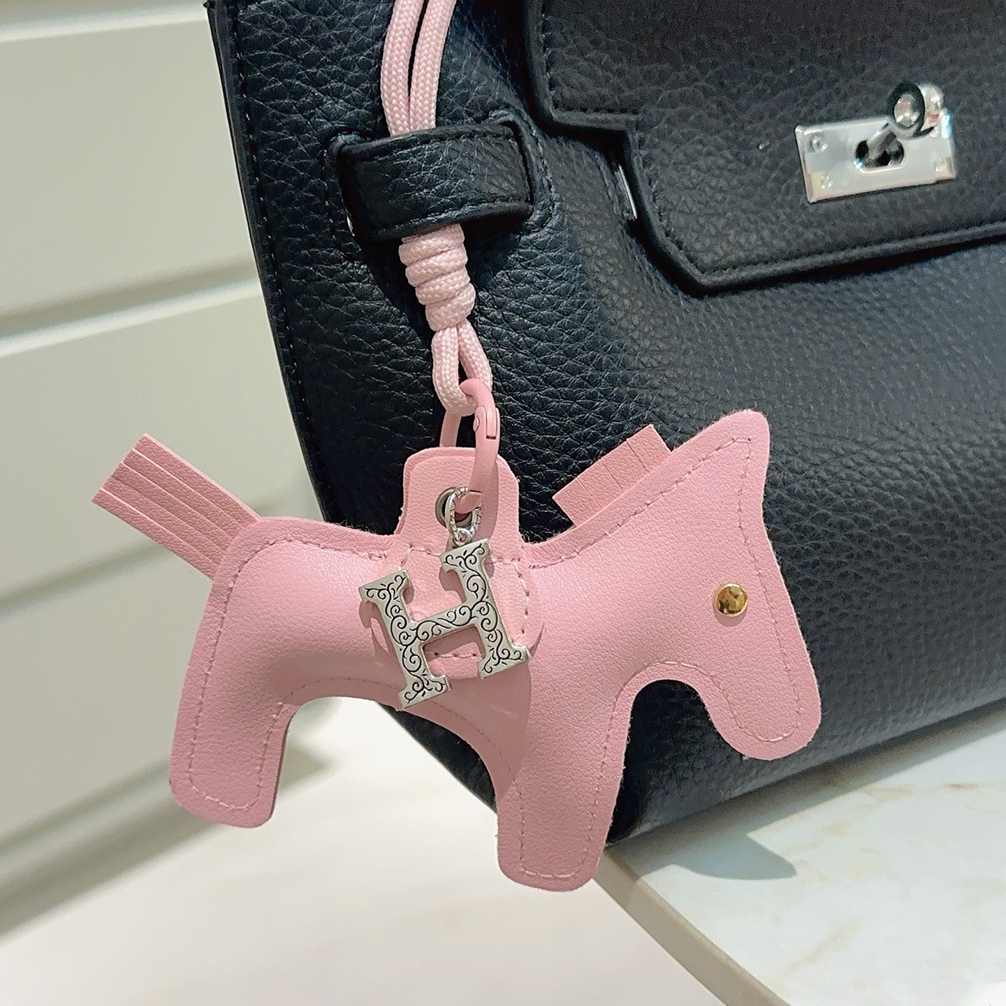 Pendentif Hermes Rodeo Horse Charm Sakura en cuir rose avec breloque H gravée argentée, clou en forme d'œil doré 12 cm