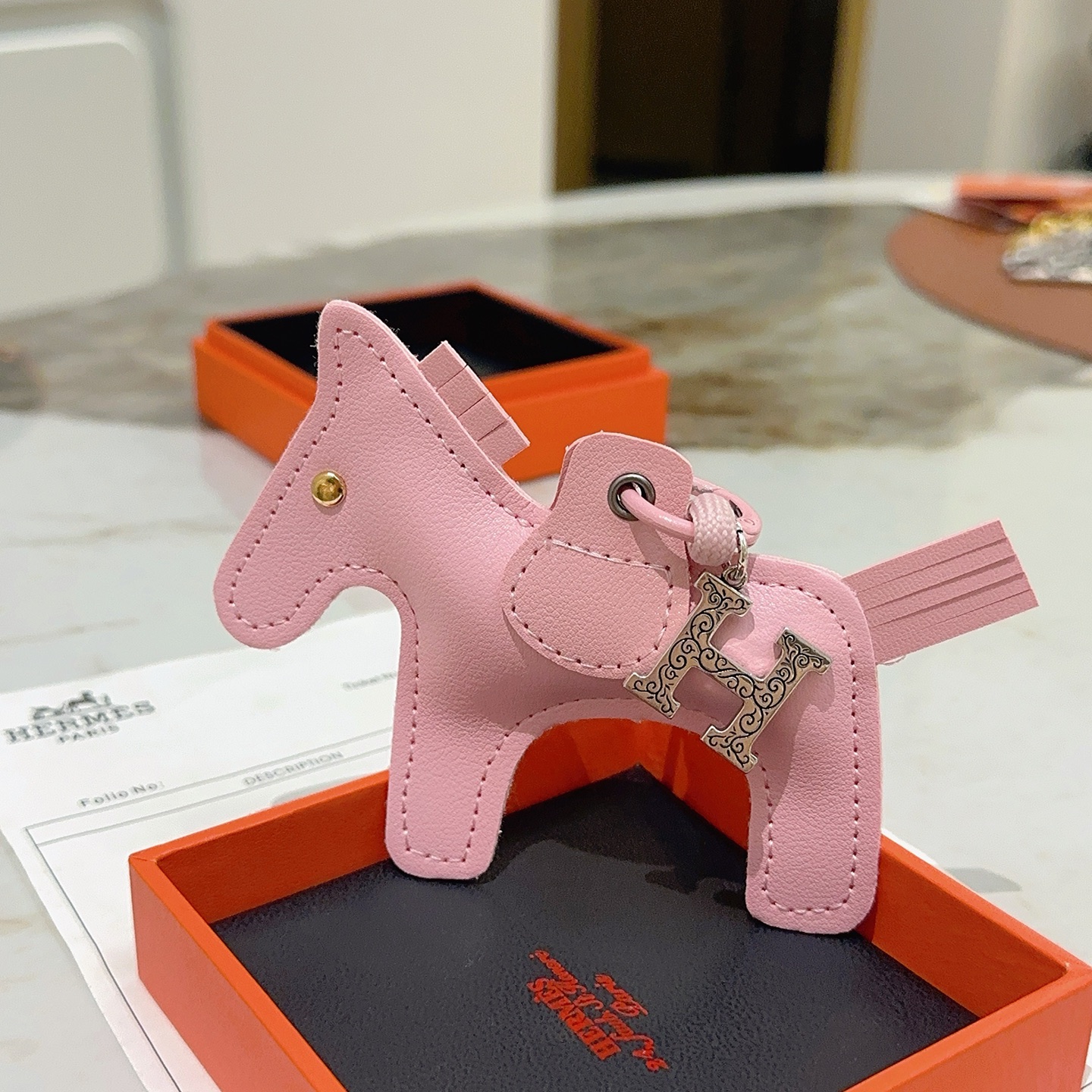 Pendentif Hermes Rodeo Horse Charm Sakura en cuir rose avec breloque H gravée argentée, clou en forme d'œil doré 12 cm