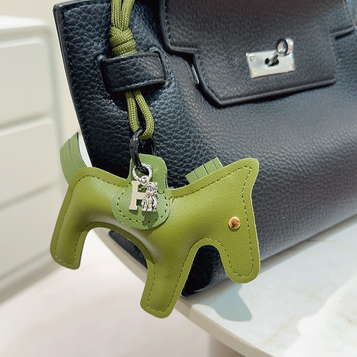 Ciondolo portachiavi Hermes Rodeo Horse Charm in pelle verde oliva con hardware in metallo argentato antico e rivetto dorato, lunghezza cordino 12 cm