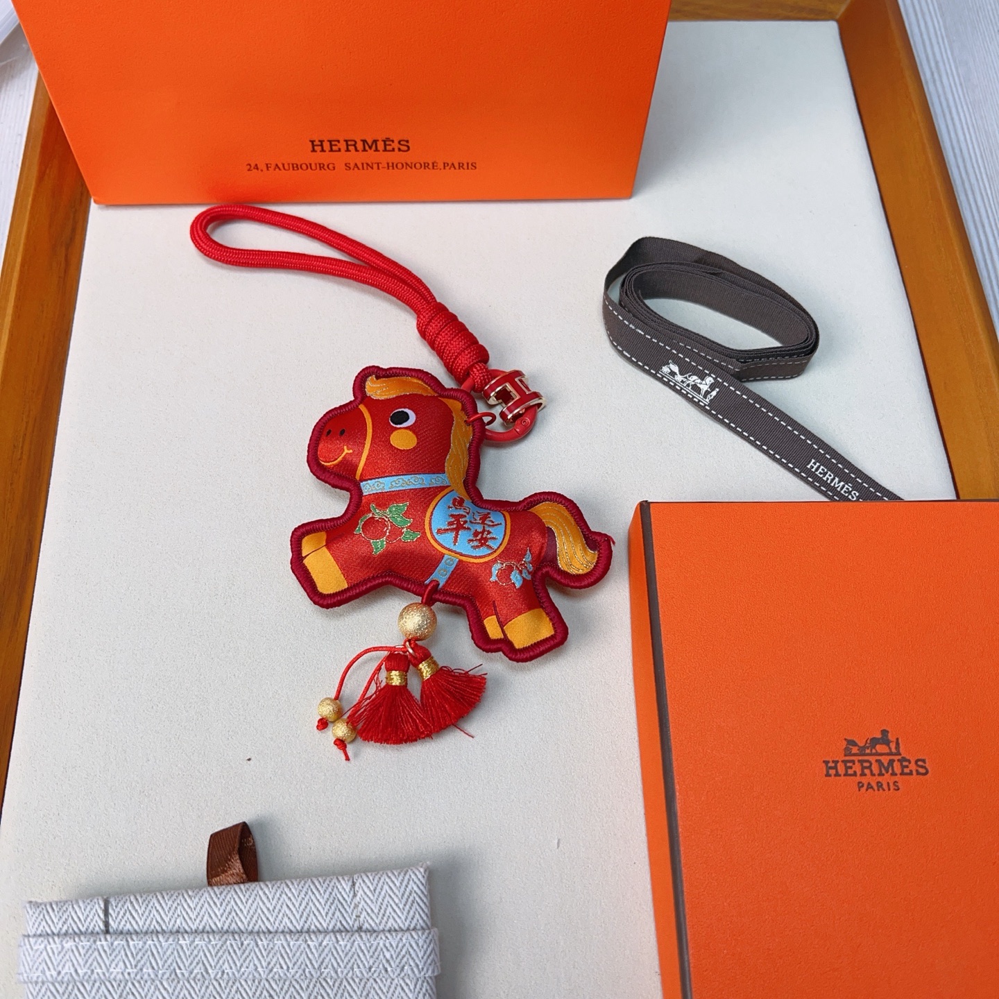 Ciondolo Hermes Anno del cavallo Lucky Nappa Tessuto rosso con dettagli decorativi oro blu verde cinturino in cordino rosso hardware in metallo color oro nappe rosse lunghezza totale 12 cm