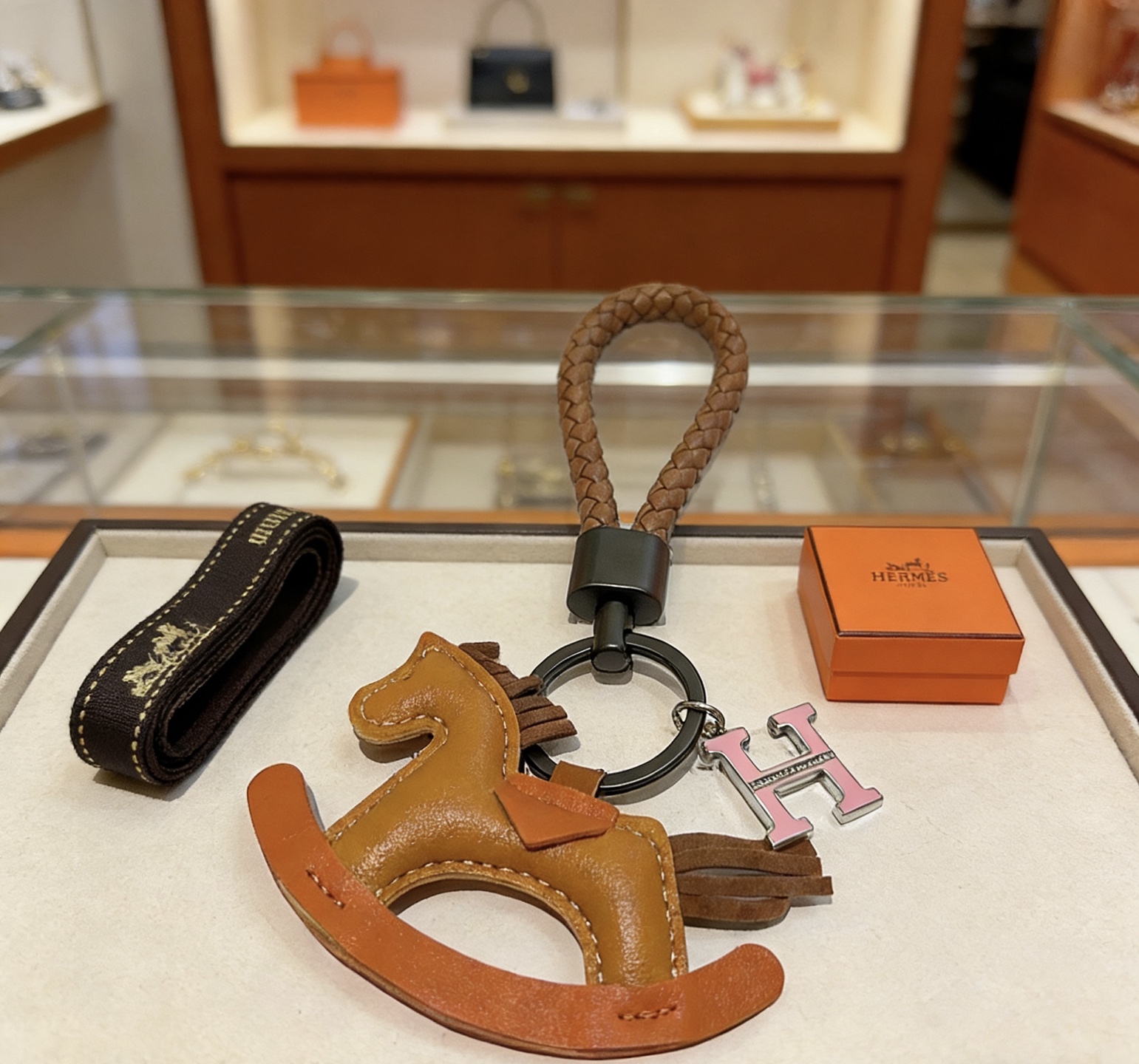 Hermes Rocking Horse H Charm Porte-clés pendentif Cuir tressé marron beige cuir orange charme de cheval à bascule matériel en bronze à canon émail rose Charme H avec détails argentés 12 cm de longueur totale