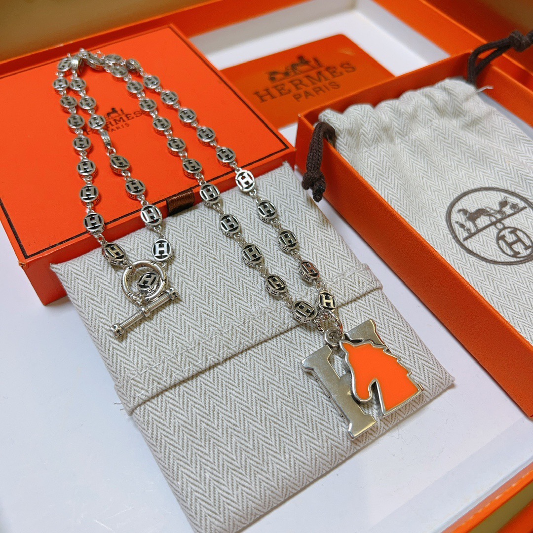 Hermes H Ciondolo testa di cavallo Farandole Collana con catena Toggle Collana in metallo argentato con dettaglio testa di cavallo in smalto arancione brillante 60 cm