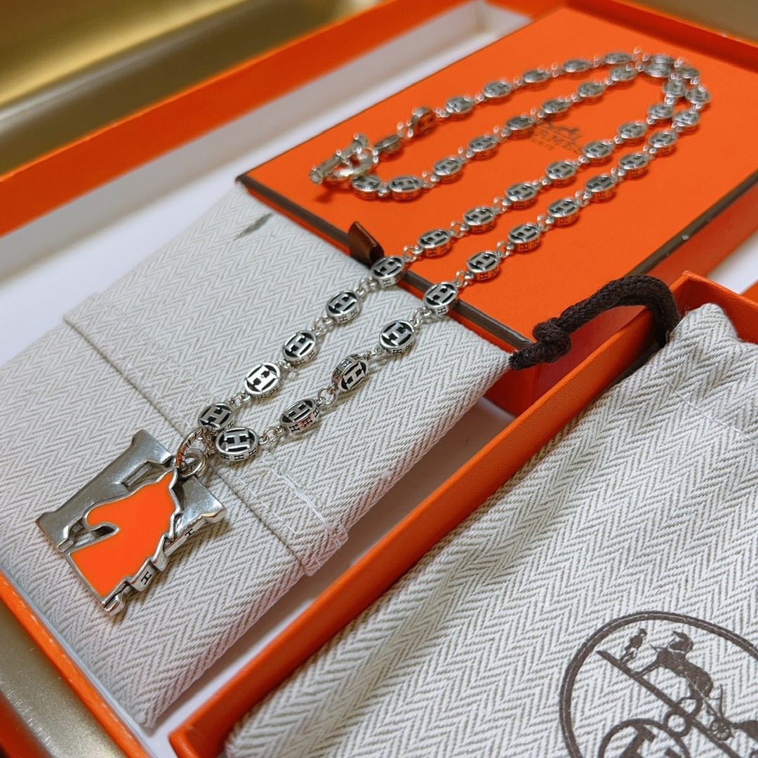 Hermes H Ciondolo testa di cavallo Farandole Collana con catena Toggle Collana in metallo argentato con dettaglio testa di cavallo in smalto arancione brillante 60 cm